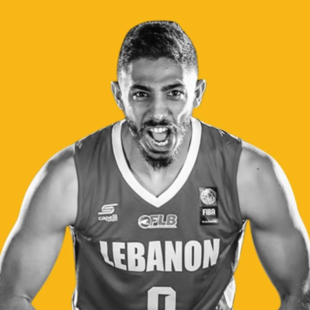 Black and white photo of a basketball player wearing a Lebanon jersey, shouting with enthusiasm against a yellow background.
