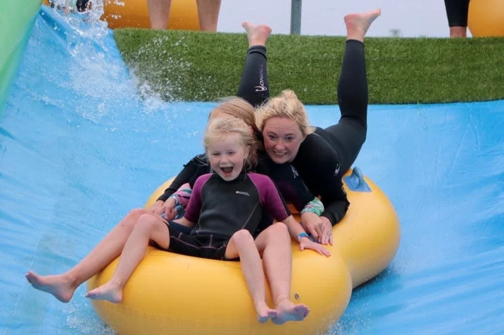 Family enjoying the Giant Slip and Slide Cornwall