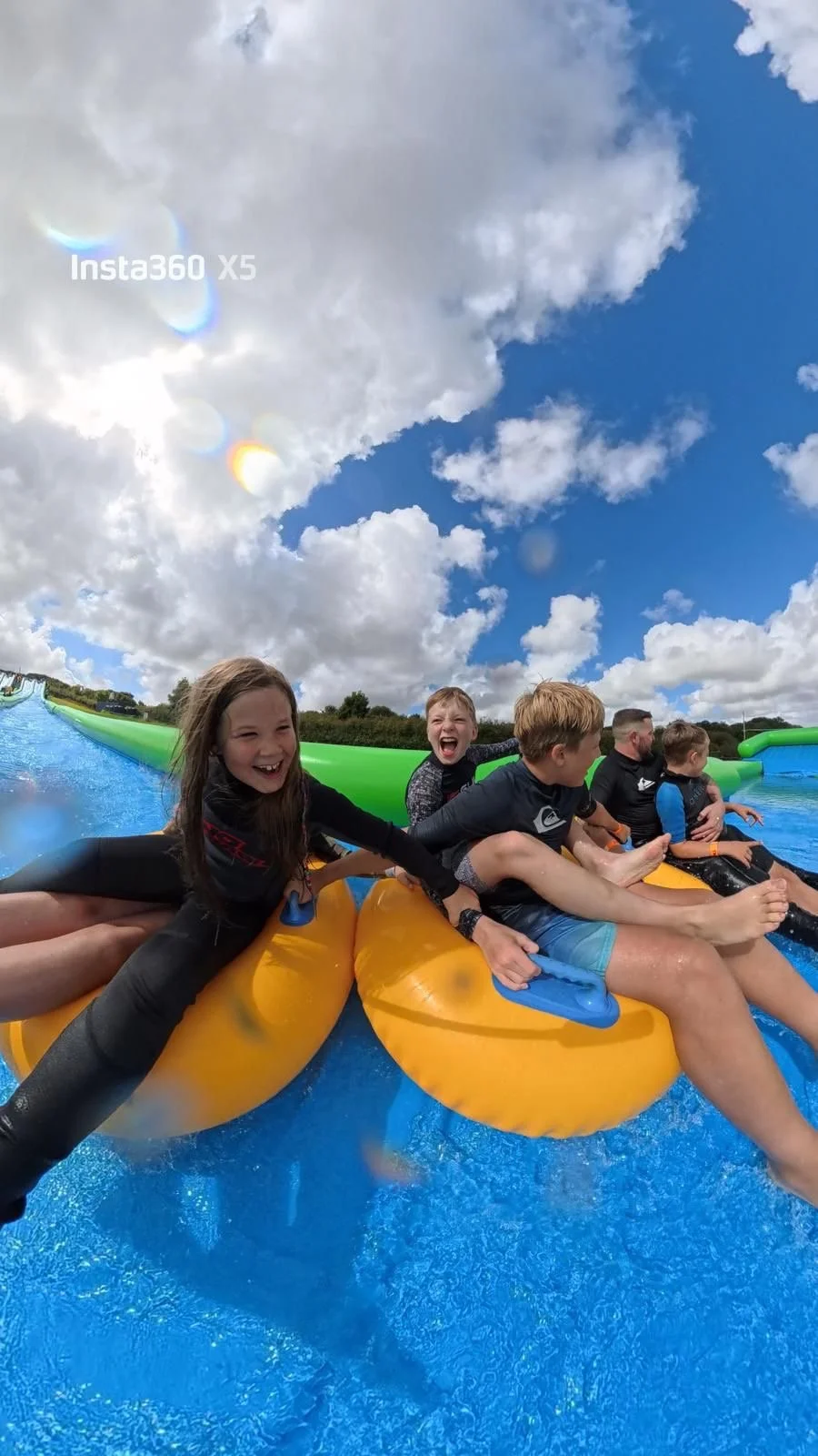 Family having fun on a slide at cornwall's largest slip and slide