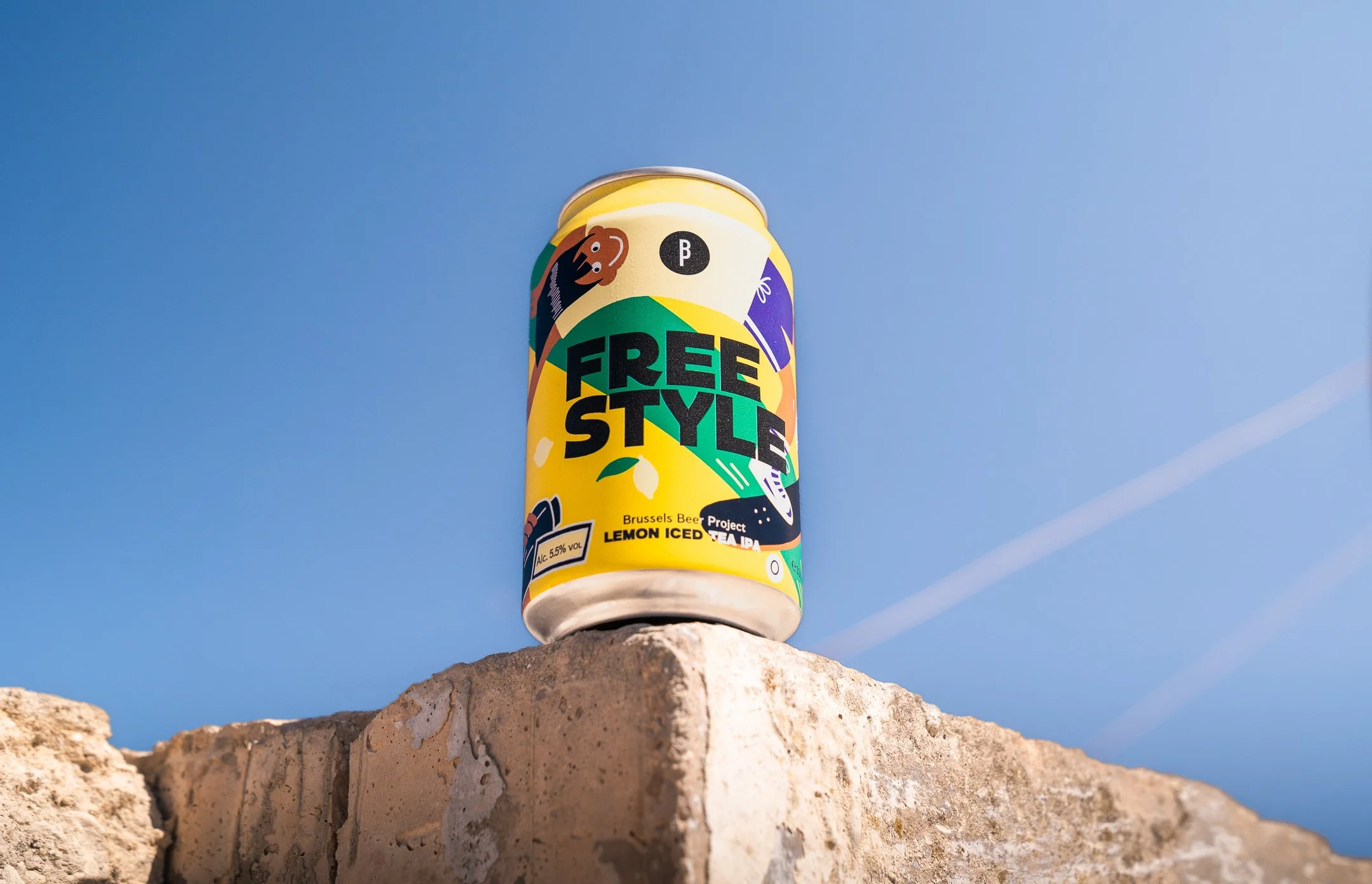 Can of Freestyle Lemon Iced Tea IPA resting on a limestone wall under a bright blue sky.
