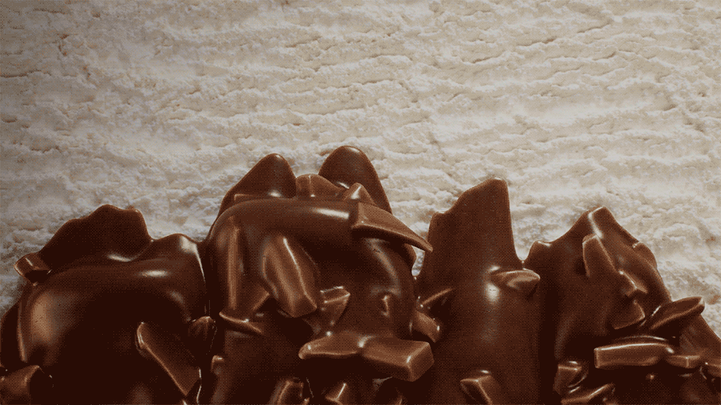 Close-up of chocolate sculptures or decorations on a textured white surface.