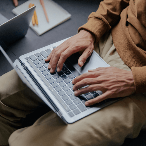 Person utilisant un ordinateur portable sur un bureau.