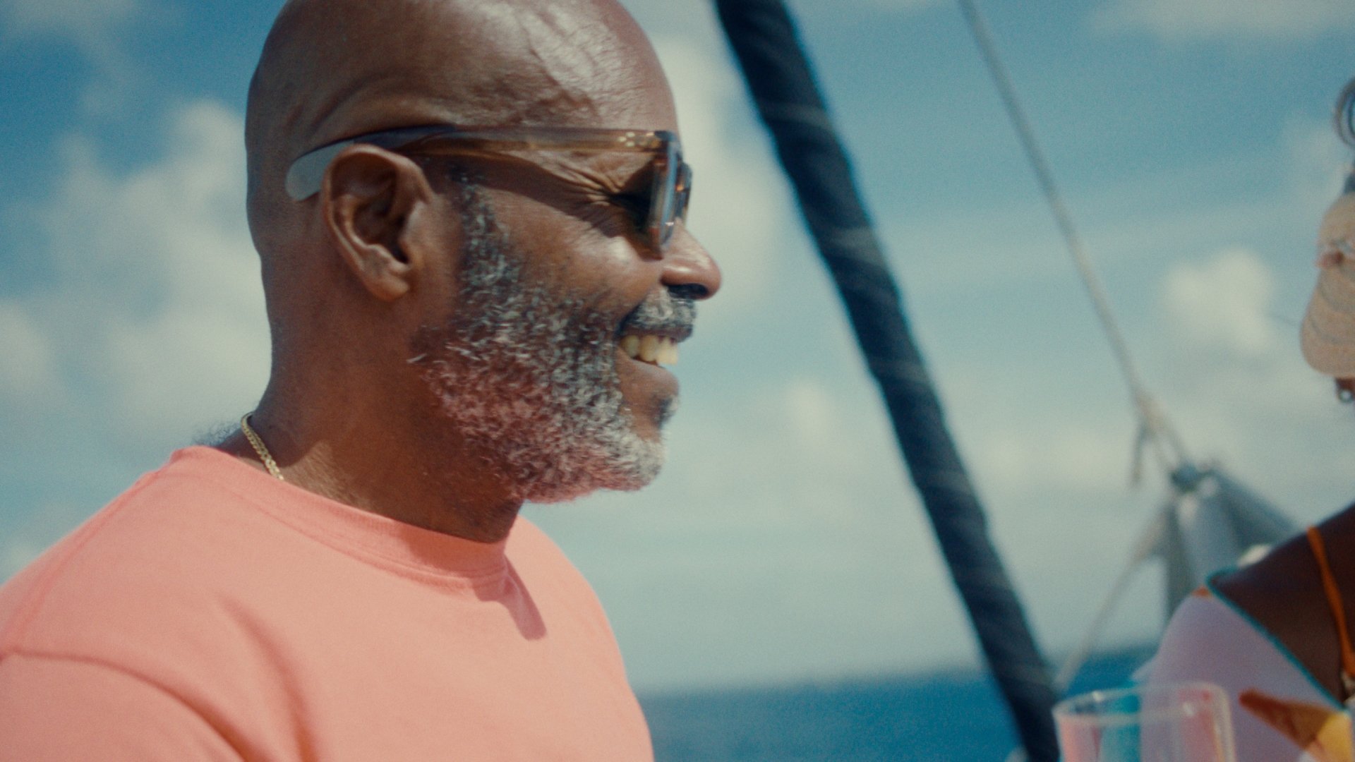 A man smiles on a boat at sea.