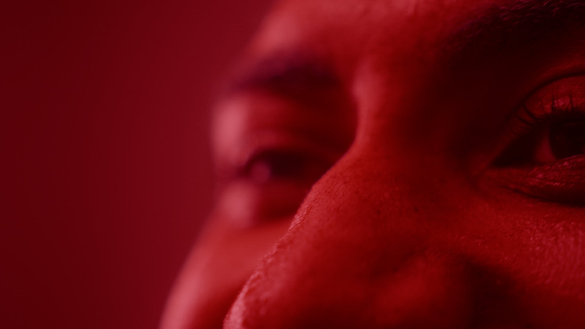 Extreme closeup on eyes bathed in red light