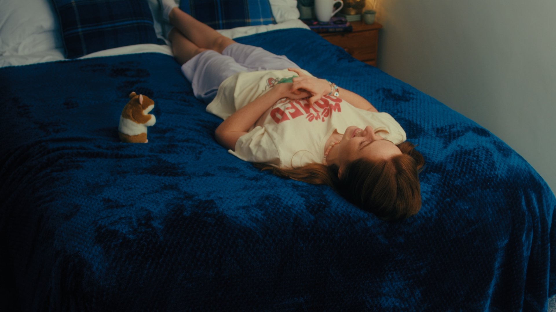 Woman lies on a bed and stares upwards.
