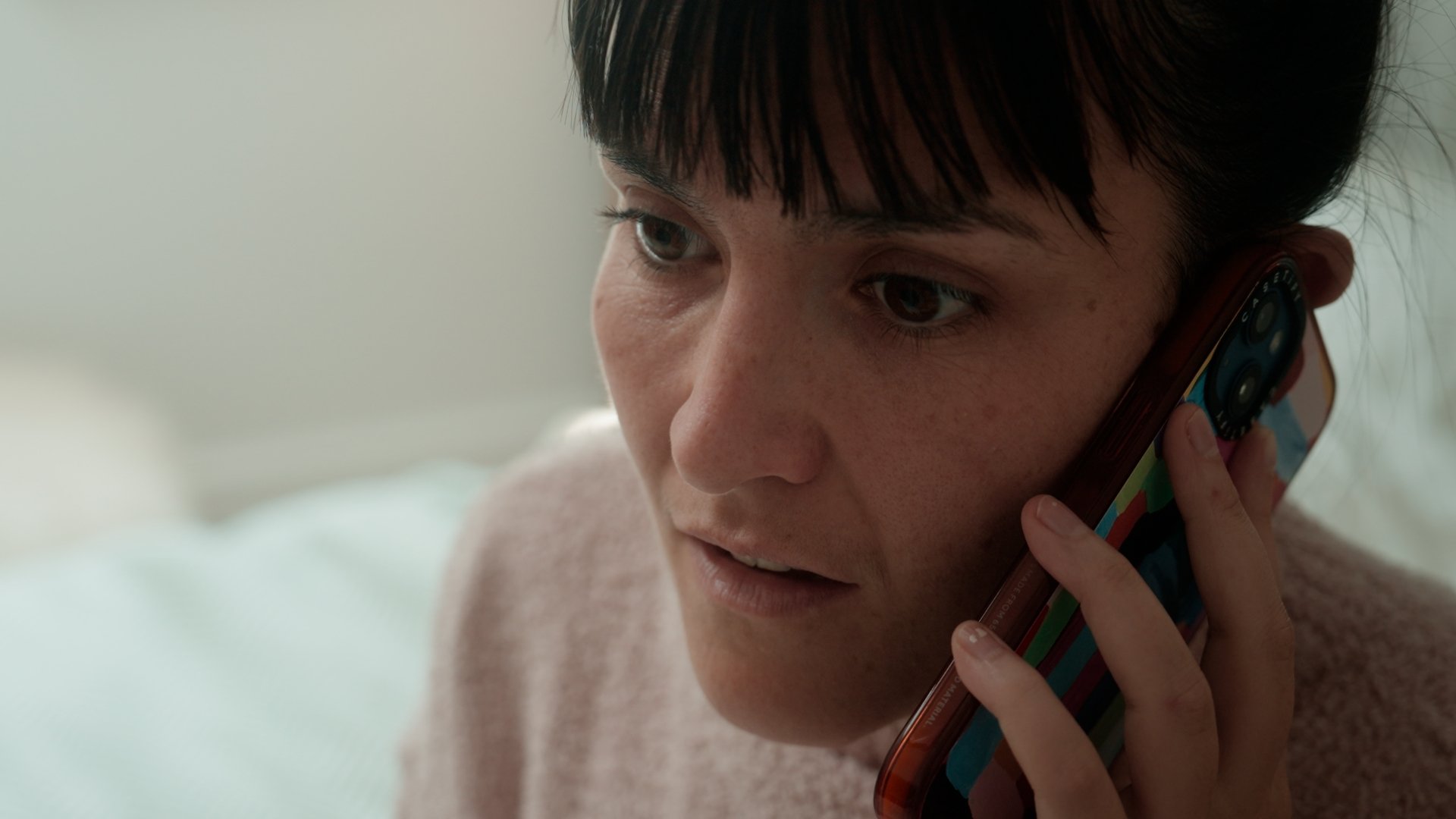A woman looks concerned on her phone call.
