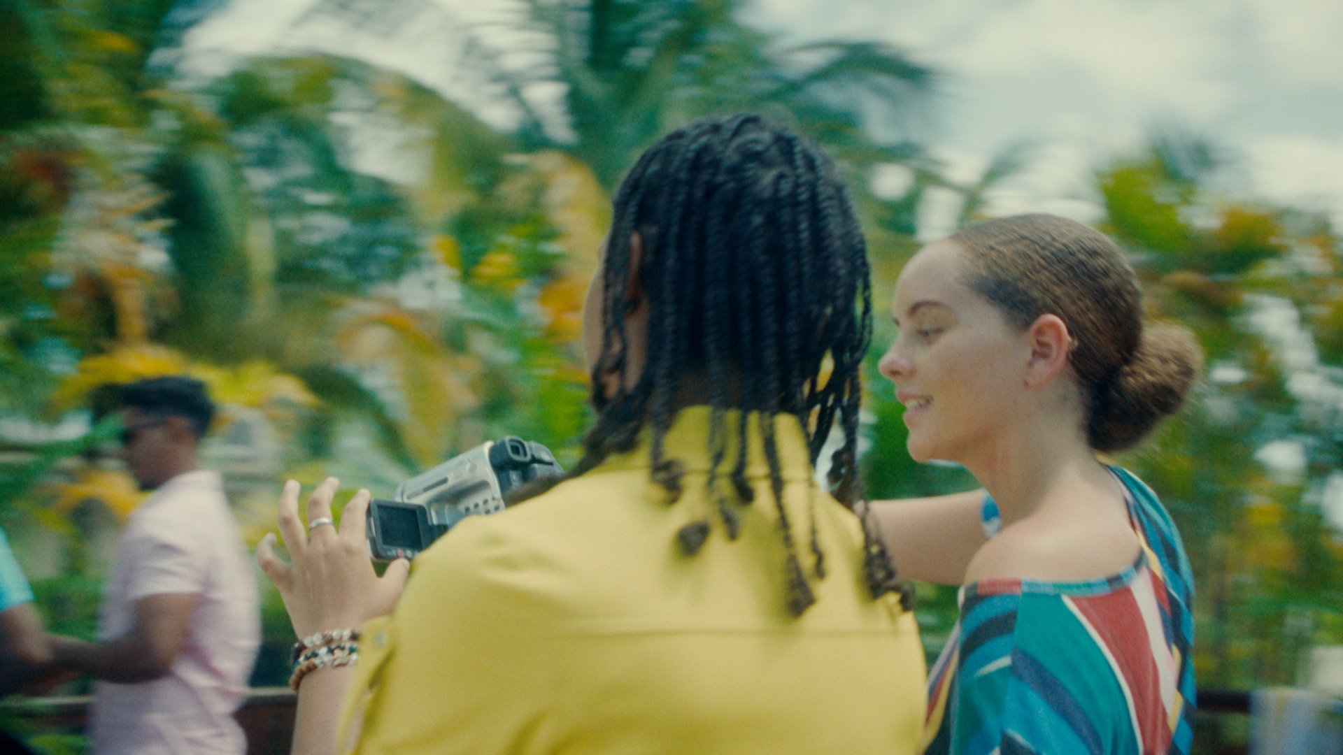 Two friends point and look at their video camera.