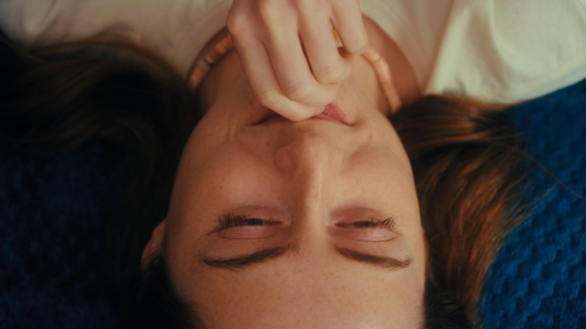 Woman is framed upside-down in a close-up.
