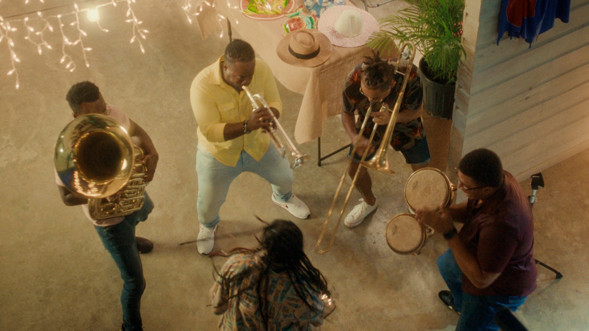 A band play under fairy lights at night.