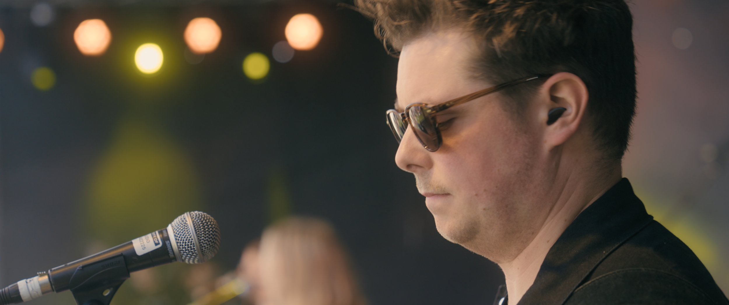 A man stands behind a microphone.