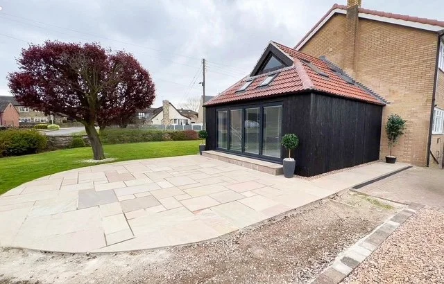 A single - storey burnt larch extension with a Dutch Barn roof and internal remodelling. Kellington East Yorkshire.