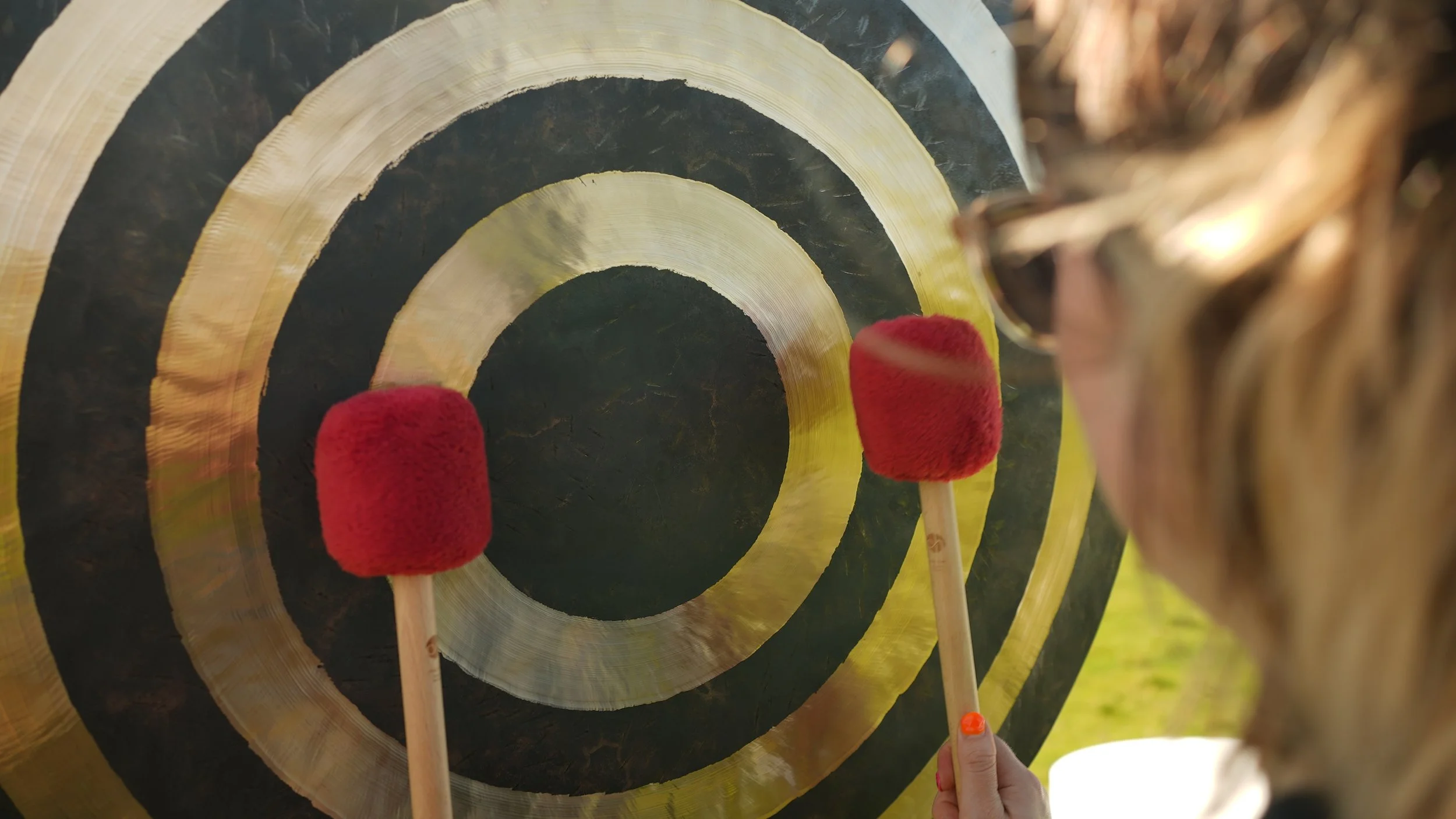 Close-up of a gong being played during a sound bath therapy session, supporting stress relief and deep relaxation.