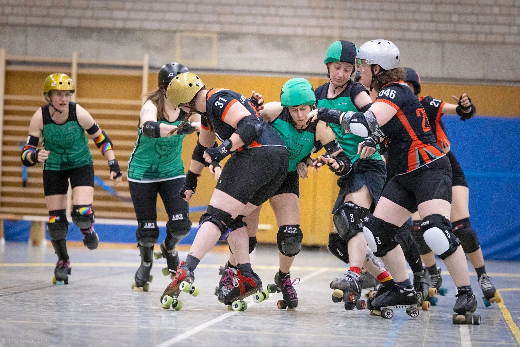 Roller Derby Mannschaft beim Spiel auf einer Rollschuhbahn.