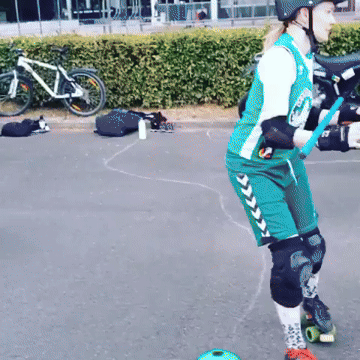 Frau beim Rollschuhlaufen mit Schutzausrüstung, im Hintergrund Fahrräder und Gegenstände auf dem Boden.