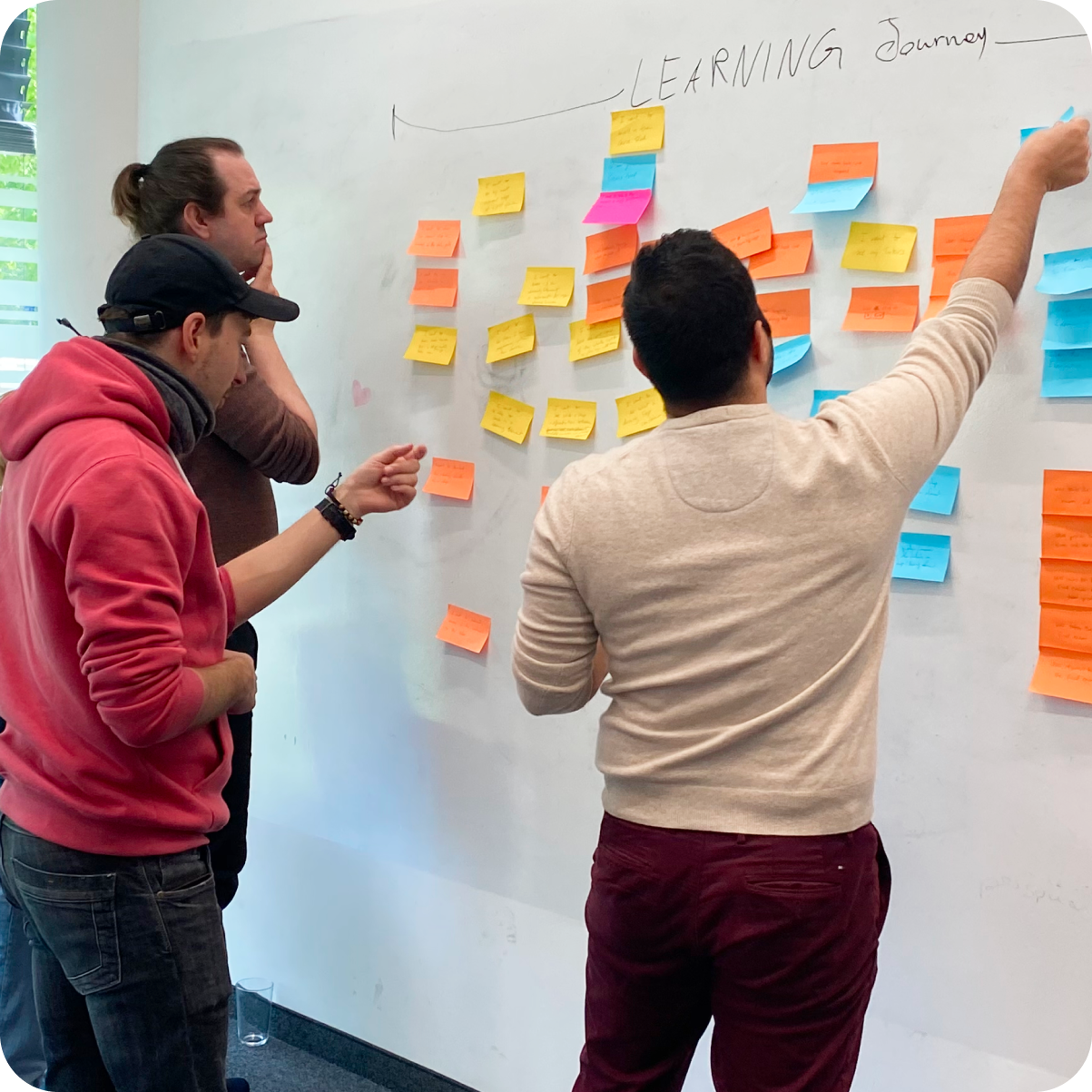 Stylized illustration of a woman with a laptop, holding a highlighter, with plant decorations, a coffee mug, and a speech bubble containing a play button, lit with a green glow.