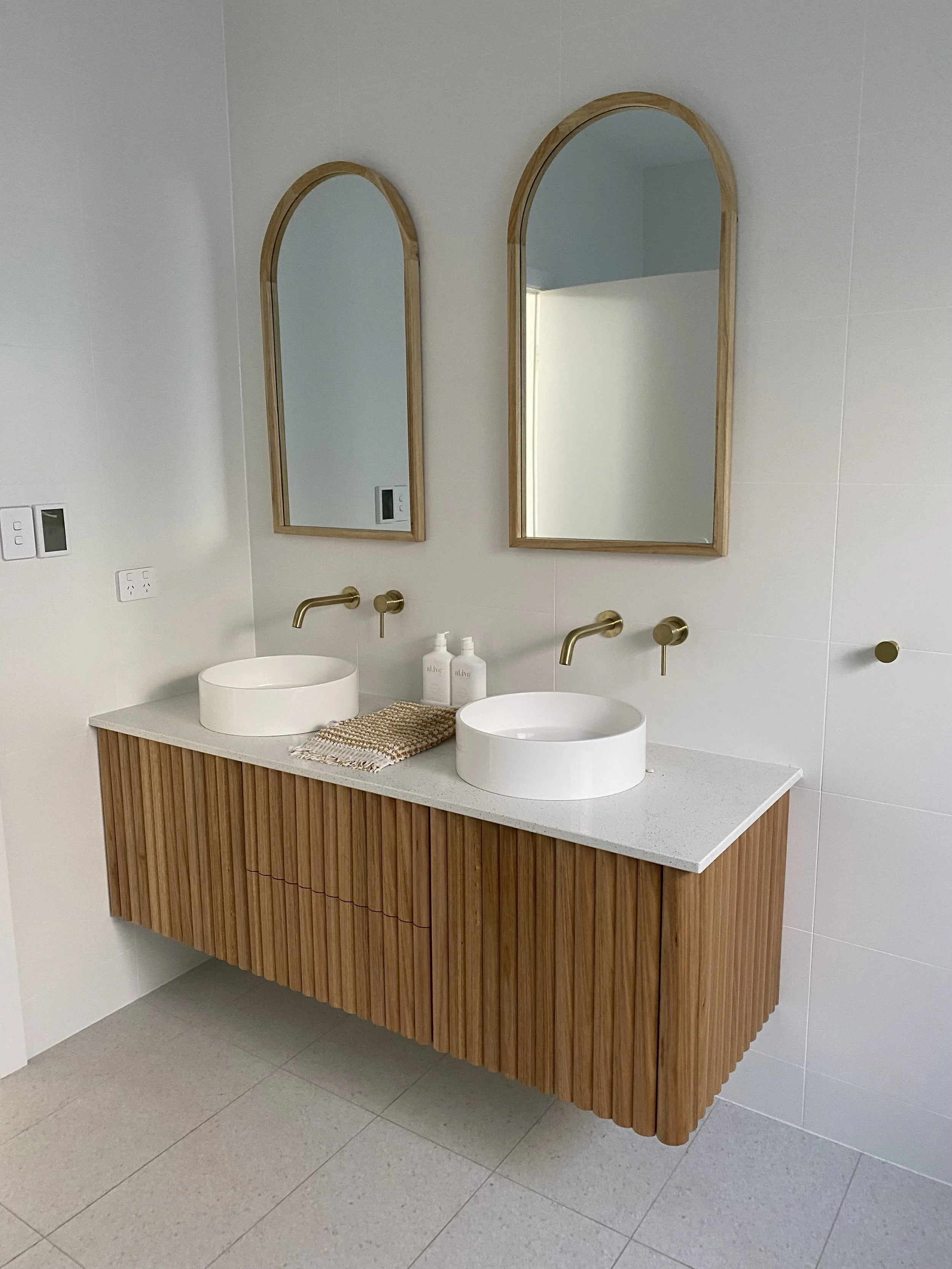 Aerial view of a construction site with multiple excavators, dump trucks, and workers working on earthmoving and site preparation.
