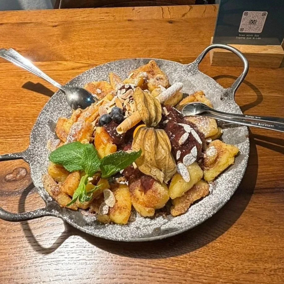   Handgerissener Kaiserschmarrn.  Luftig, goldbraun und herrlich süß – mit fruchtigem Zwetschgenröster und feinen Mandelblättchen. 