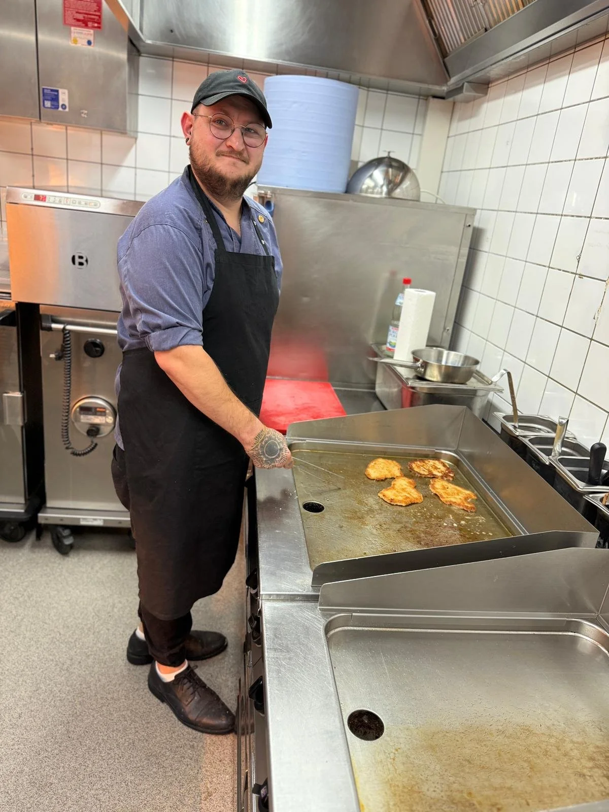  Ein Koch in der Küche bei der Arbeit, er brät  Medaillons. 