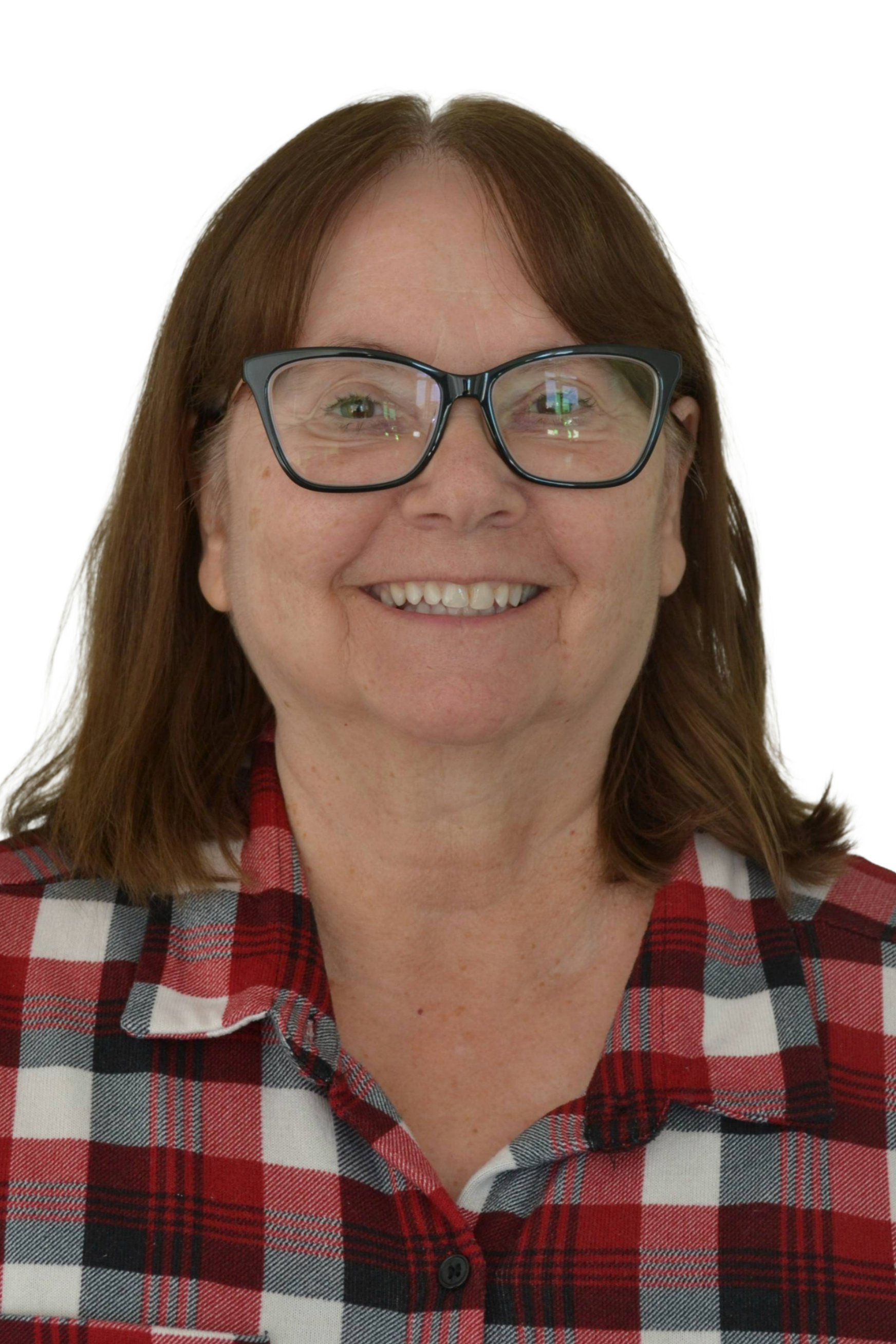Young woman with long dark hair, makeup, and a red top, sitting inside a vehicle, looking at the camera.