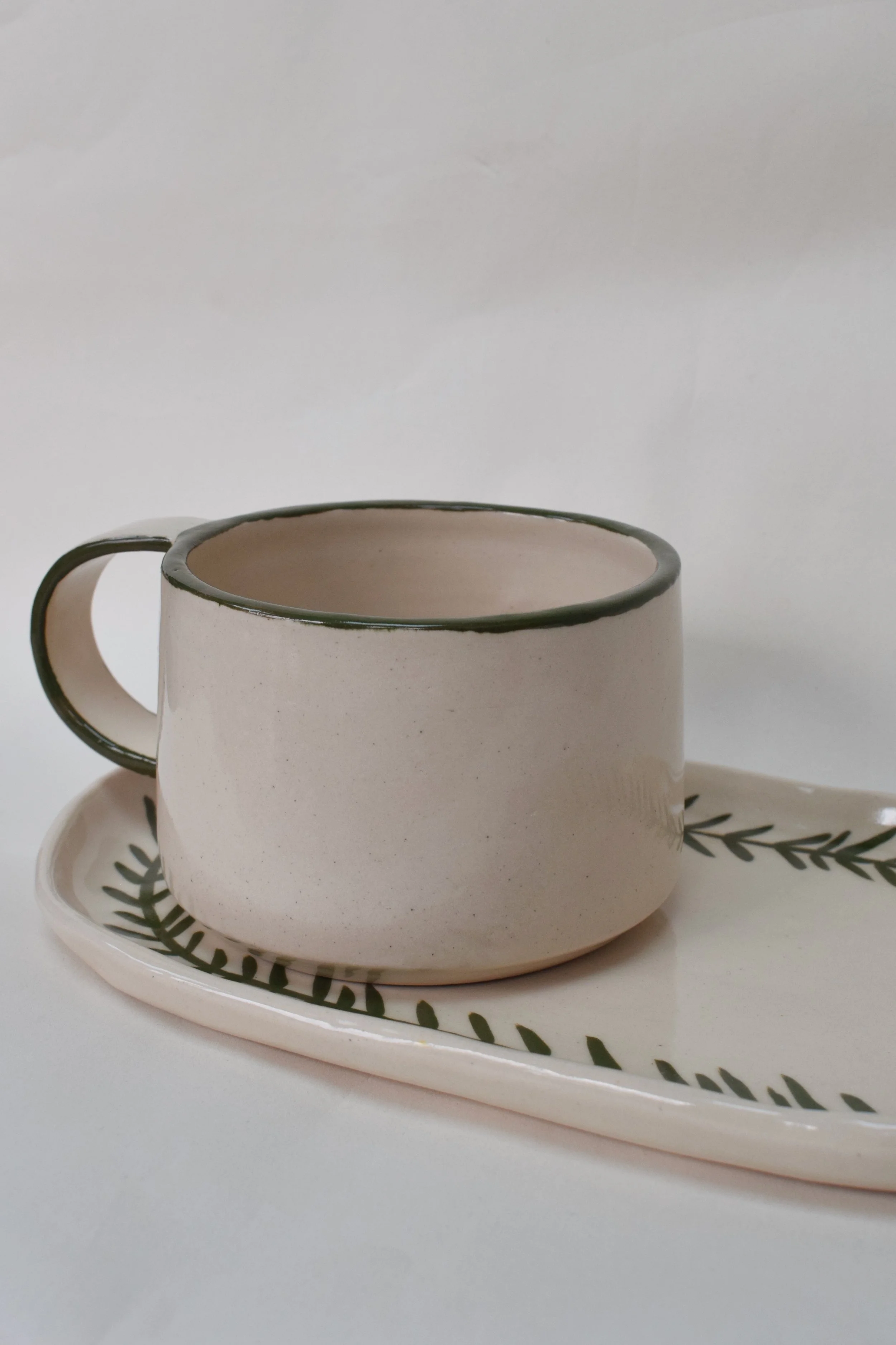 J Lucas Pottery_green edge coffee cub with frond tray.jpeg