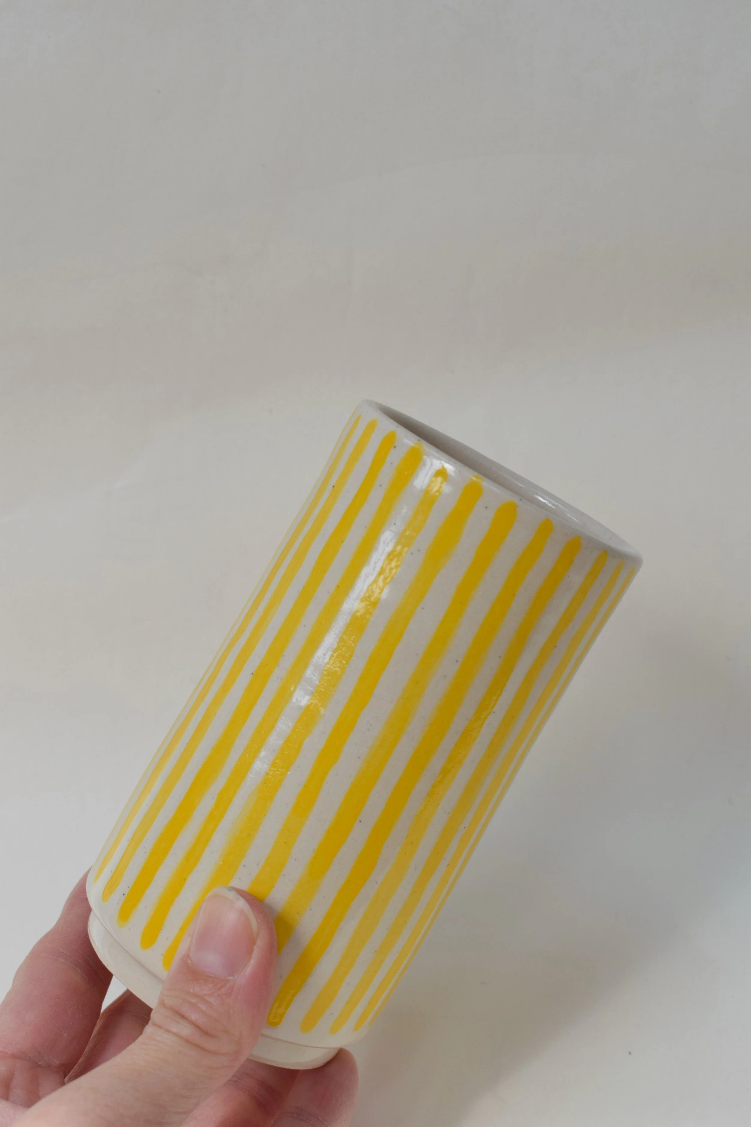 J Lucas Pottery_yellow small vase narrow stripes_held.jpeg