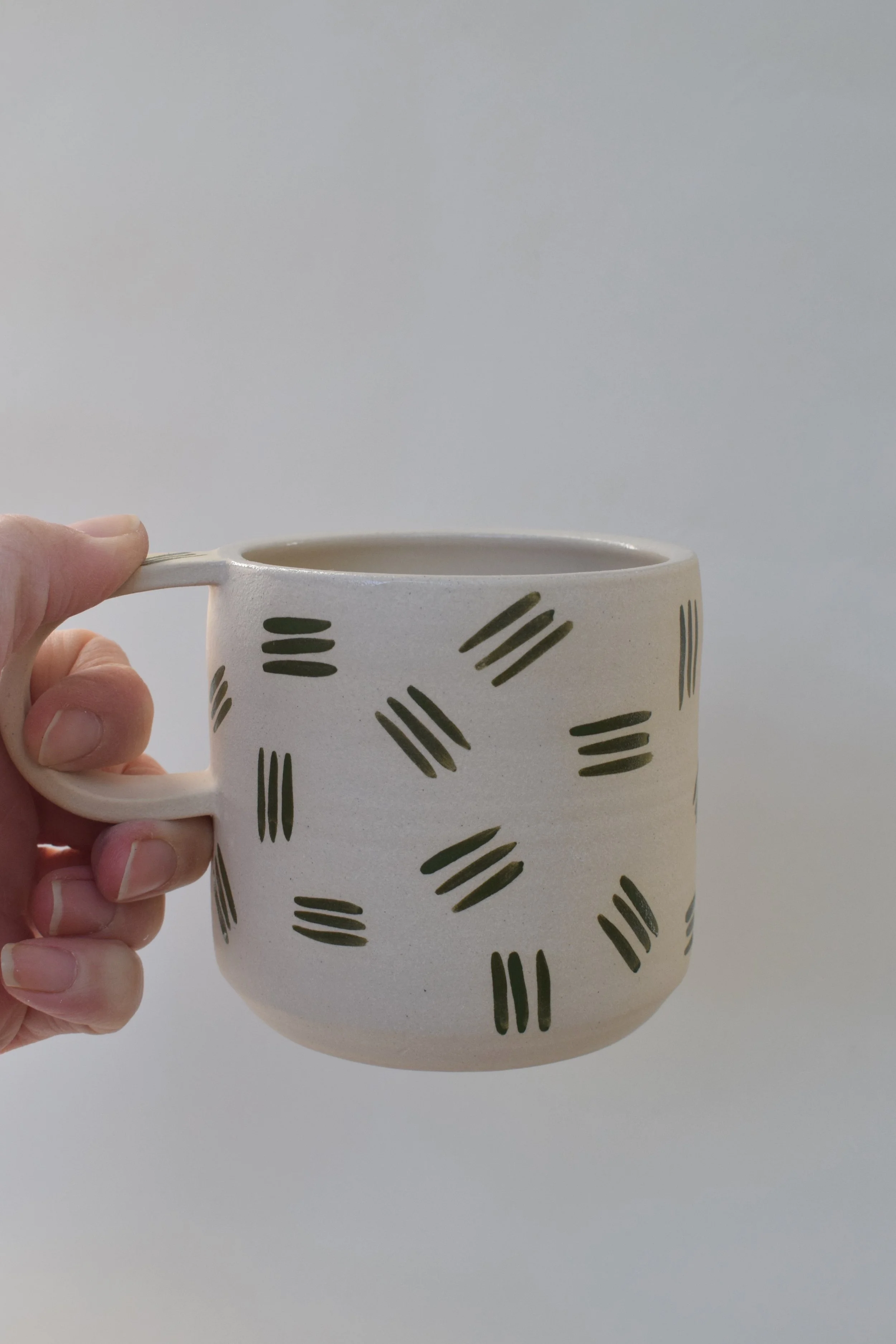 J Lucas Pottery_green dash mug_held.jpeg