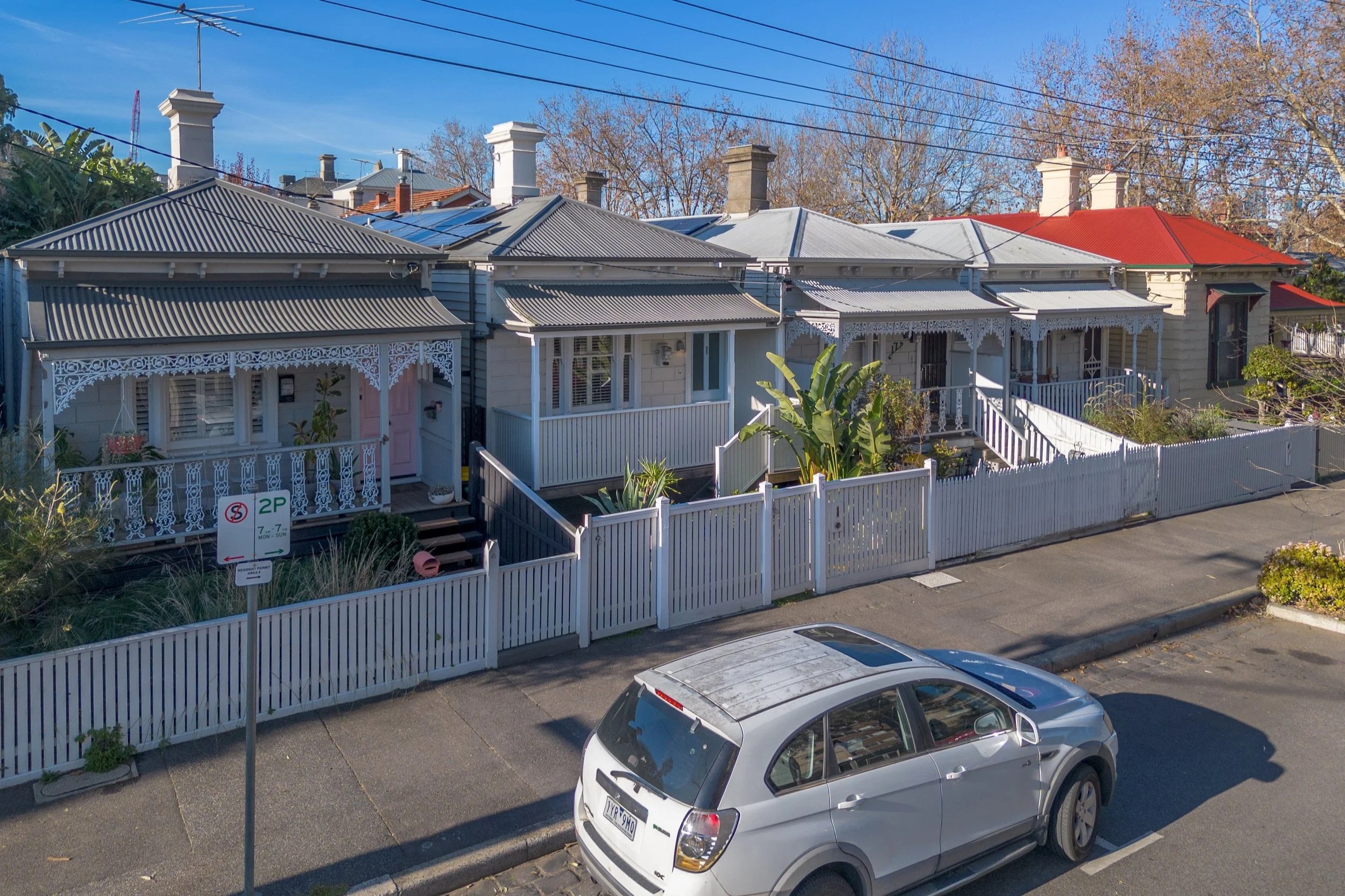 An aerial view of a residential property with a marked area of 240 square meters, showing a backyard, backyard deck, neighboring houses, and parked cars along the street.