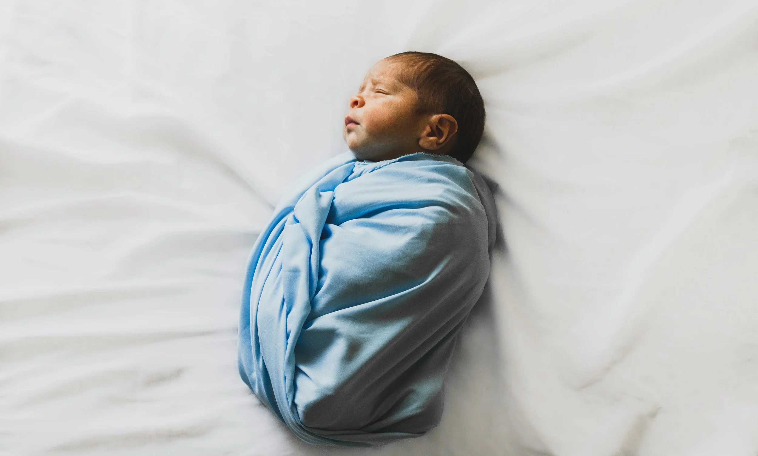 Baby laying on bed with mom wondering do I have postpartum anxiety?