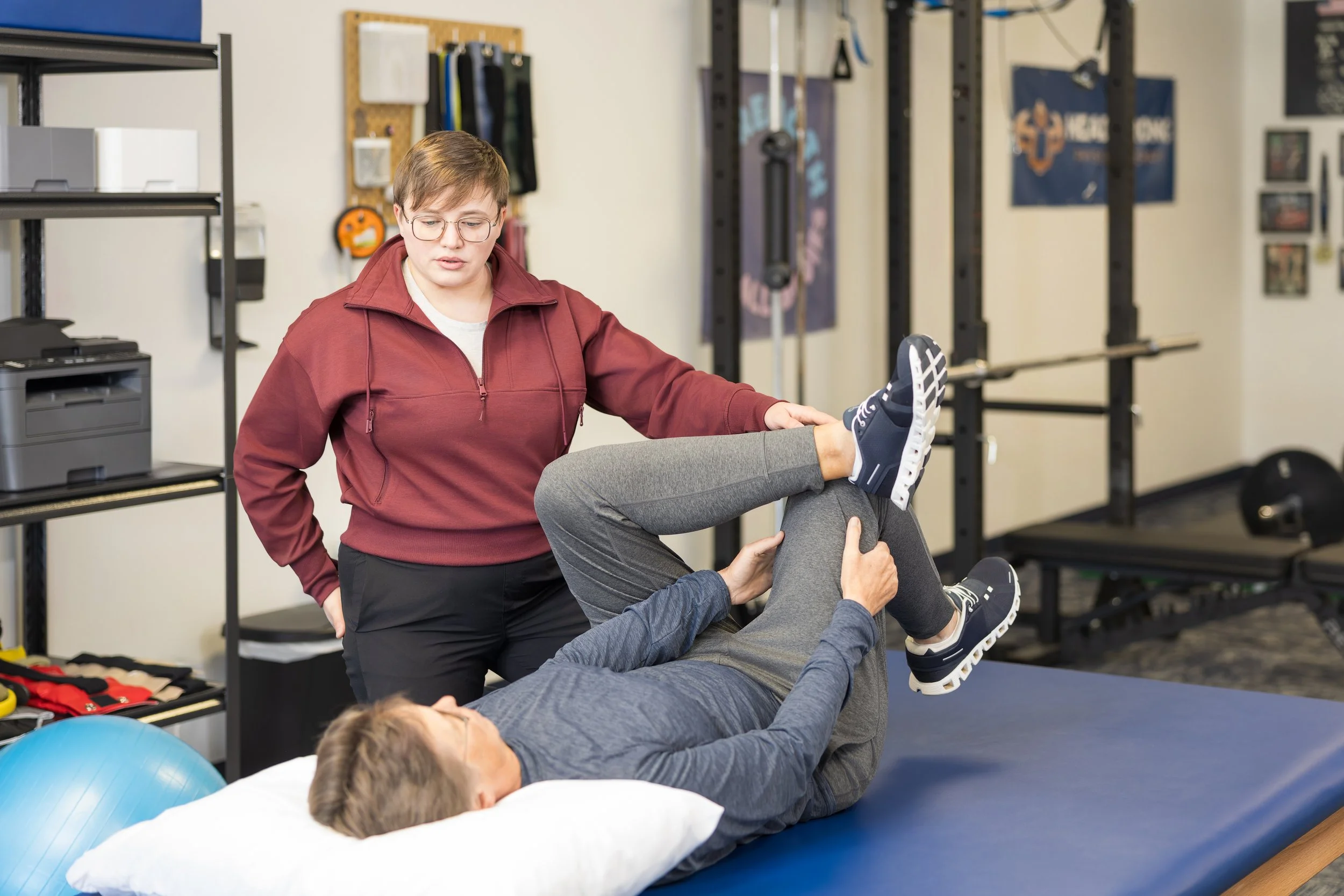 Physical therapist instructing supine exercise for patient with postural orthostatic tachycardia syndrome.