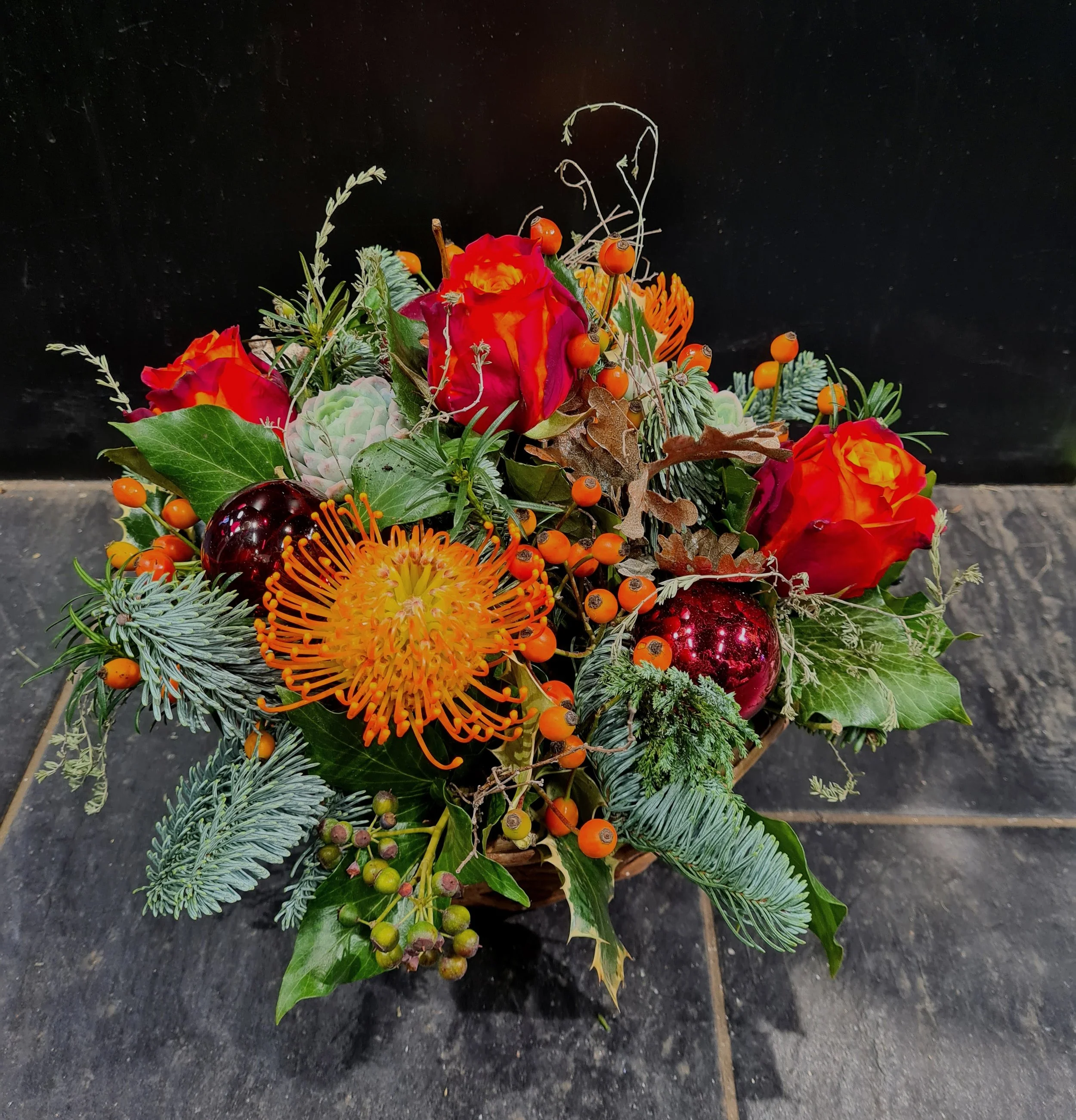 weihnachtliches Gesteck in rot/orange