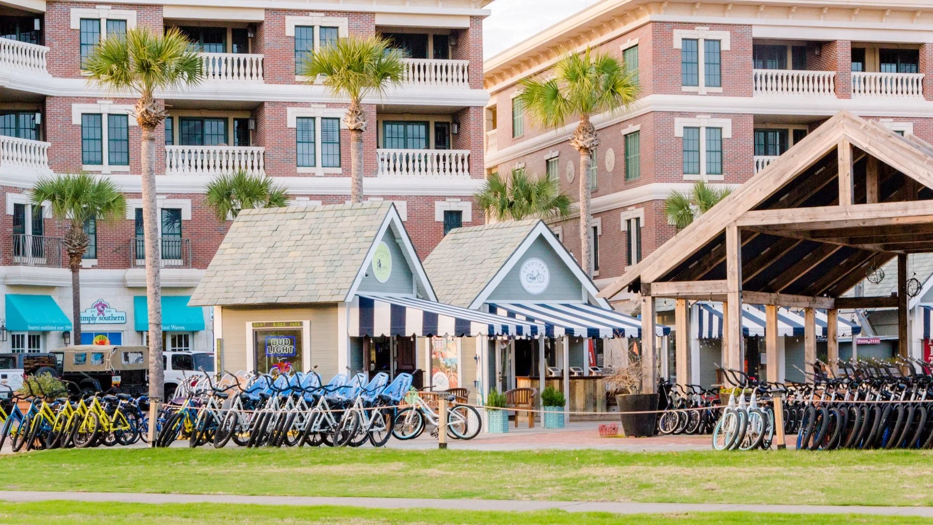 Seacrest Beach Town Square with numerous bicycles parked outside, and palm trees in the scene.