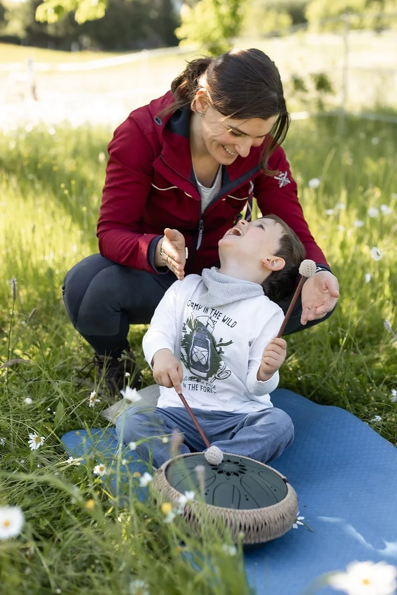 Ätherische Öle für Kinder: Ein Kind riecht interessiert an den Händen von Anja Haselhofer und entdeckt verschiedene Naturdüfte.