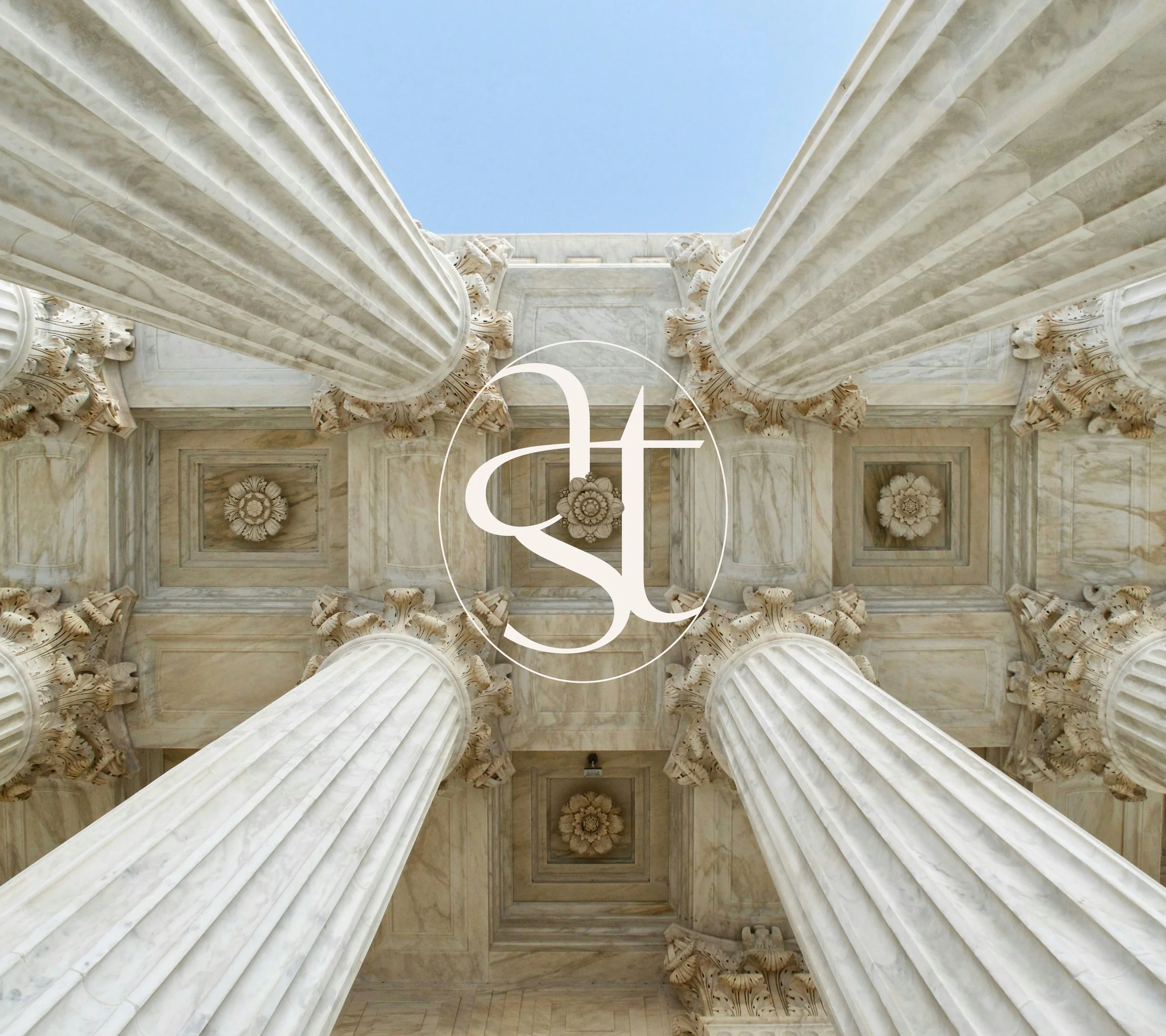 Présentation du logo d’Altheas Avocats. Vue en contre-plongée de colonnes en marbre avec des détails sculptés avec incrustation du logo rond Altheas.