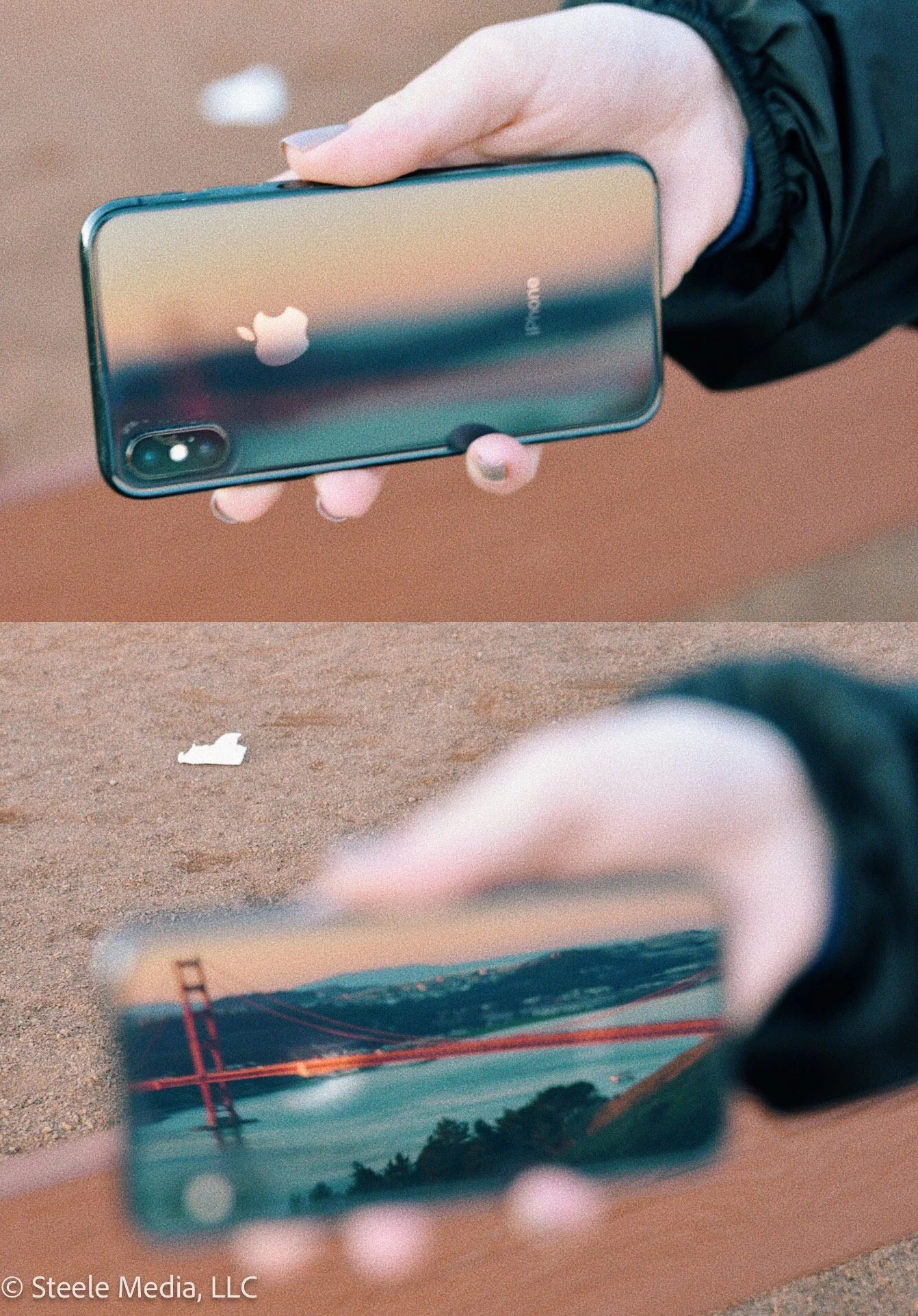 Close-up of a person holding an iPhone with a reflective back, showing the Apple logo, with the Golden Gate Bridge visible on the screen, and a beige-colored surface beneath.