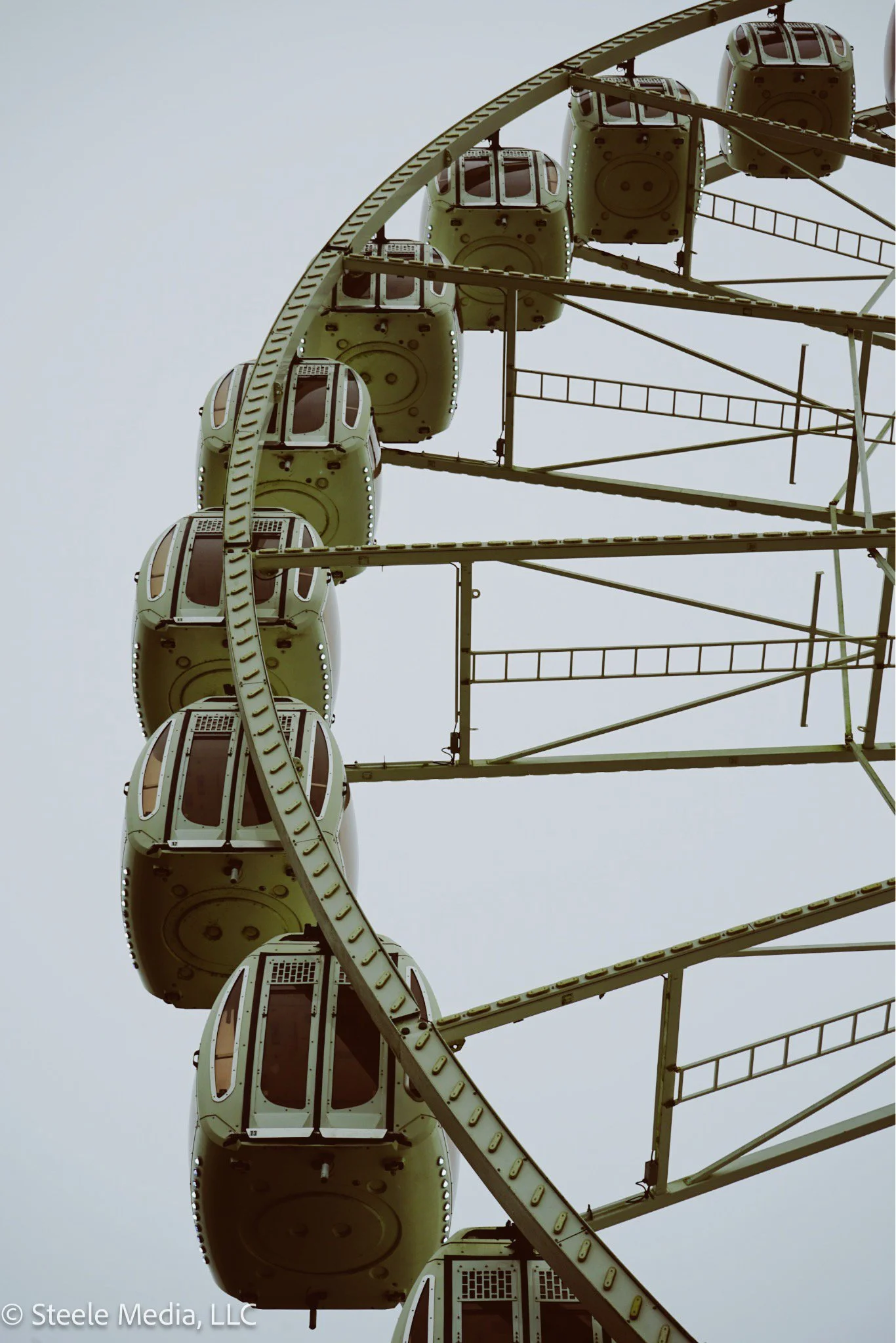 A close-up of a Ferris wheel with enclosed passenger cabins.