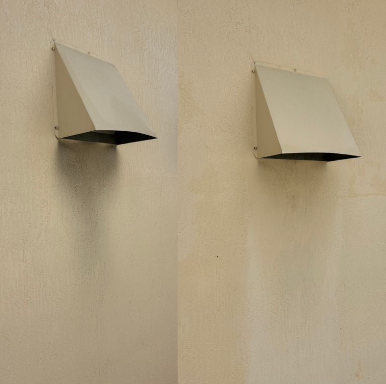 Two metal wall-mounted exhaust vents on a beige exterior wall.