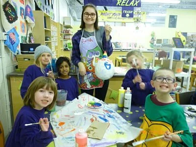 A young woman and five children are making arts and crafts during a summer art class at Wet Paint Pottery in Saskatoon.