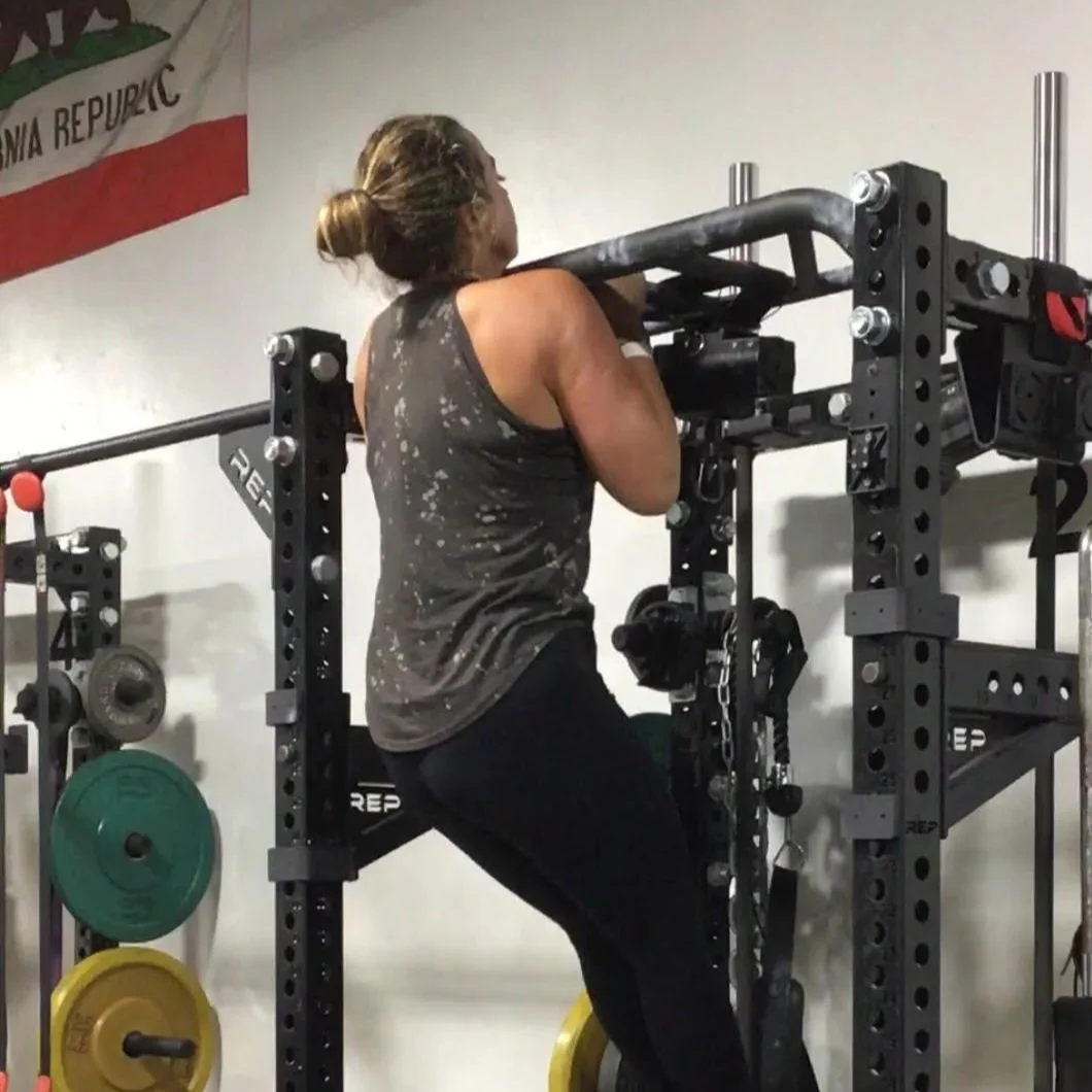 A strong woman completes a pull-up.
