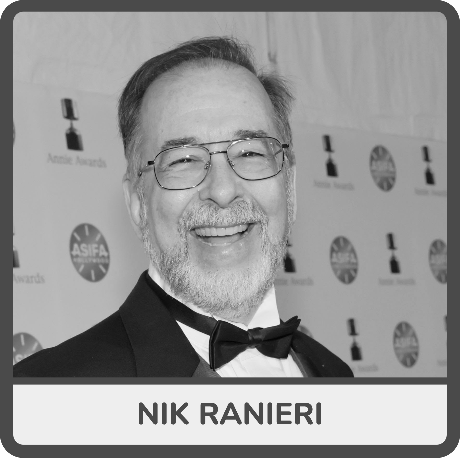 Black and white photo of Nik Ranieri wearing glasses and a tuxedo with a bow tie, smiling at an awards event, with a backdrop featuring ASIFA logos and trophy icons.