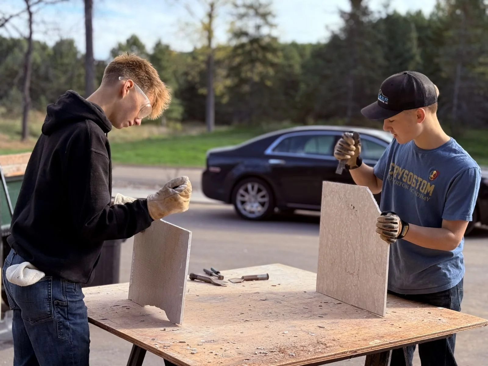 Two people standing in front of a construction site of a building with arches, columns, and wooden framing.