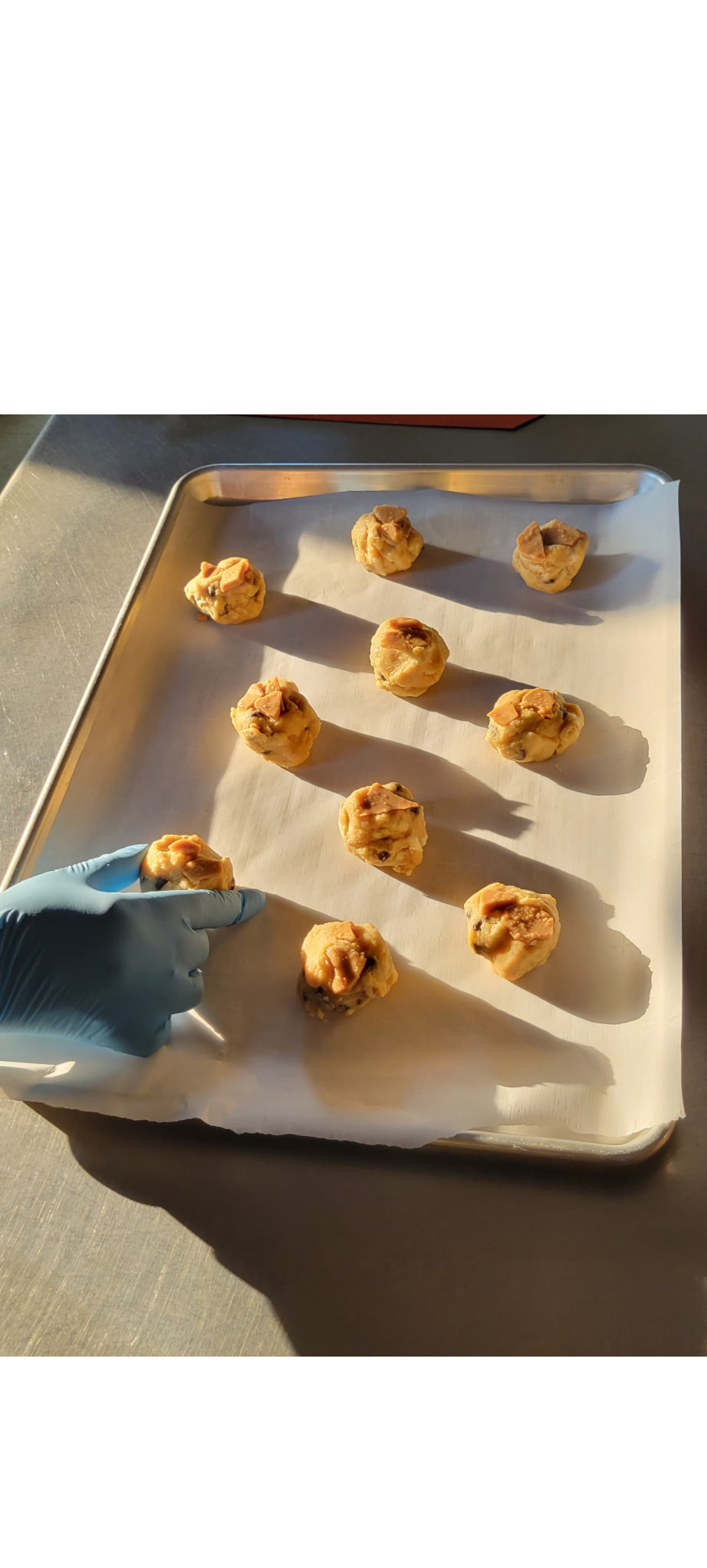 Mounds of cookie dough arranged on a baking sheet, ready for the oven.