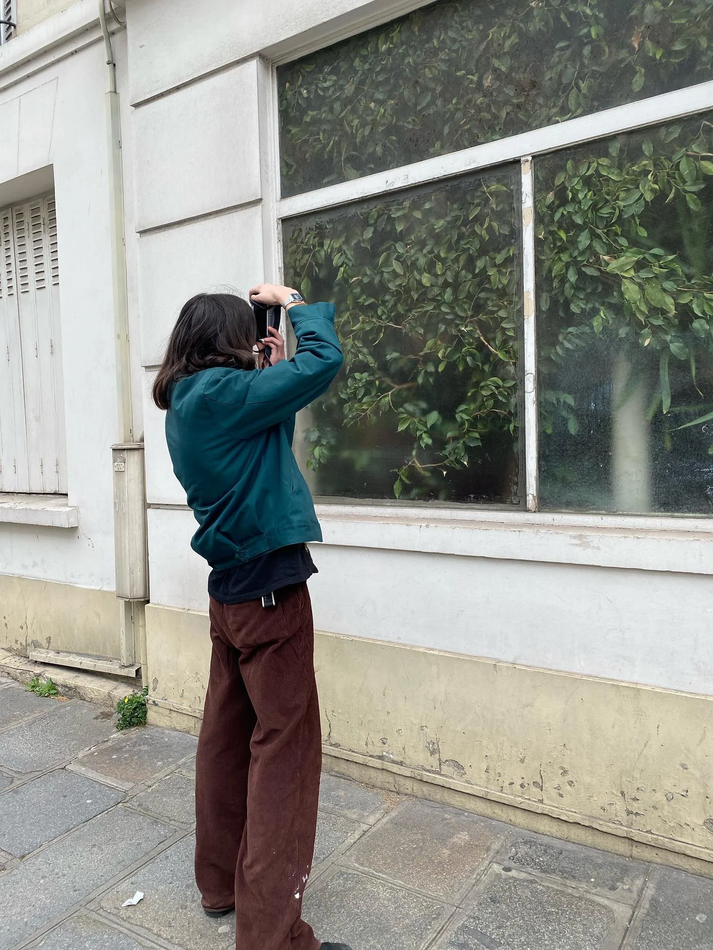 Junge Frau fotografiert eine Fensterscheibe eines Gebäudes