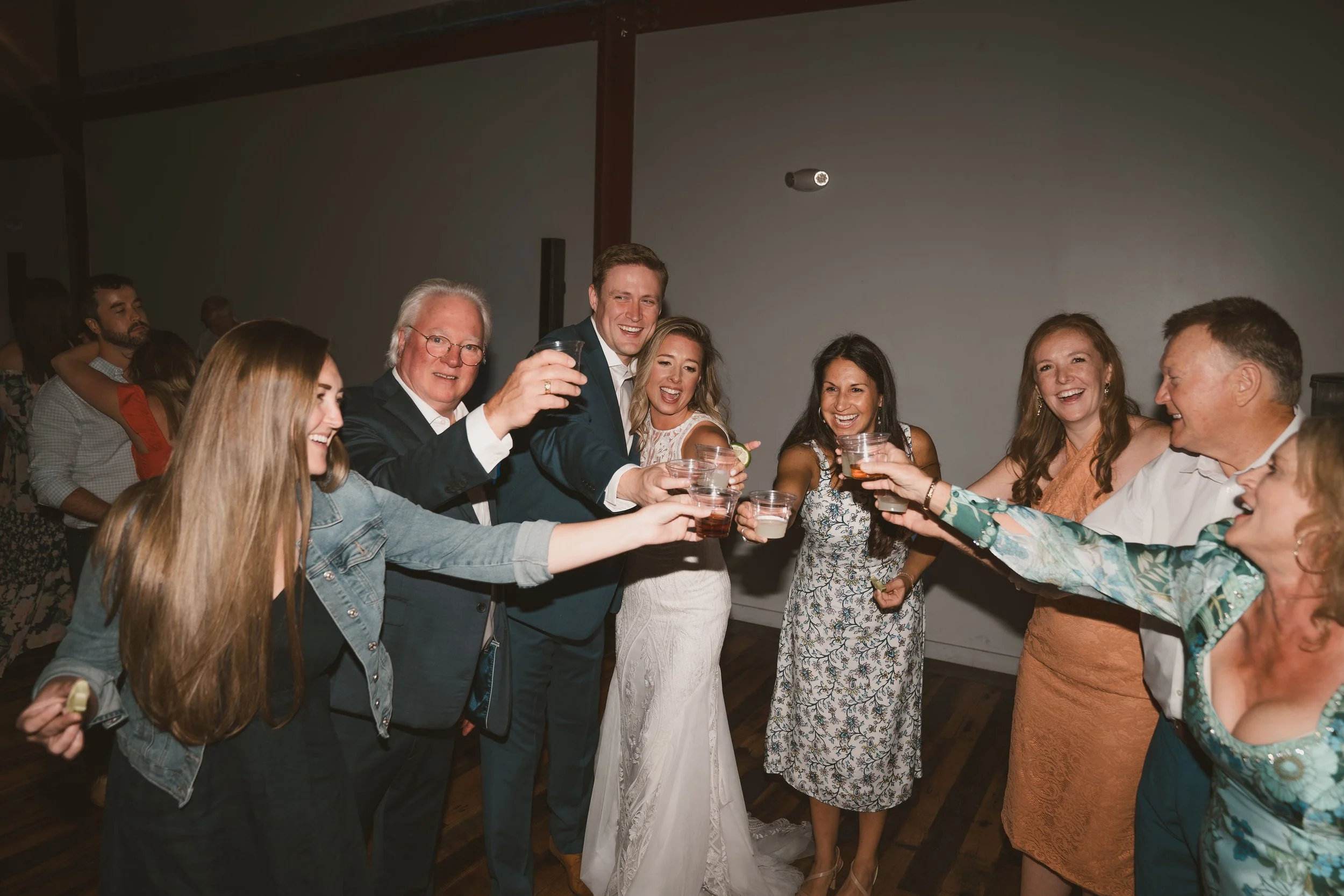 Group of people at a celebration, clinking glasses and smiling.