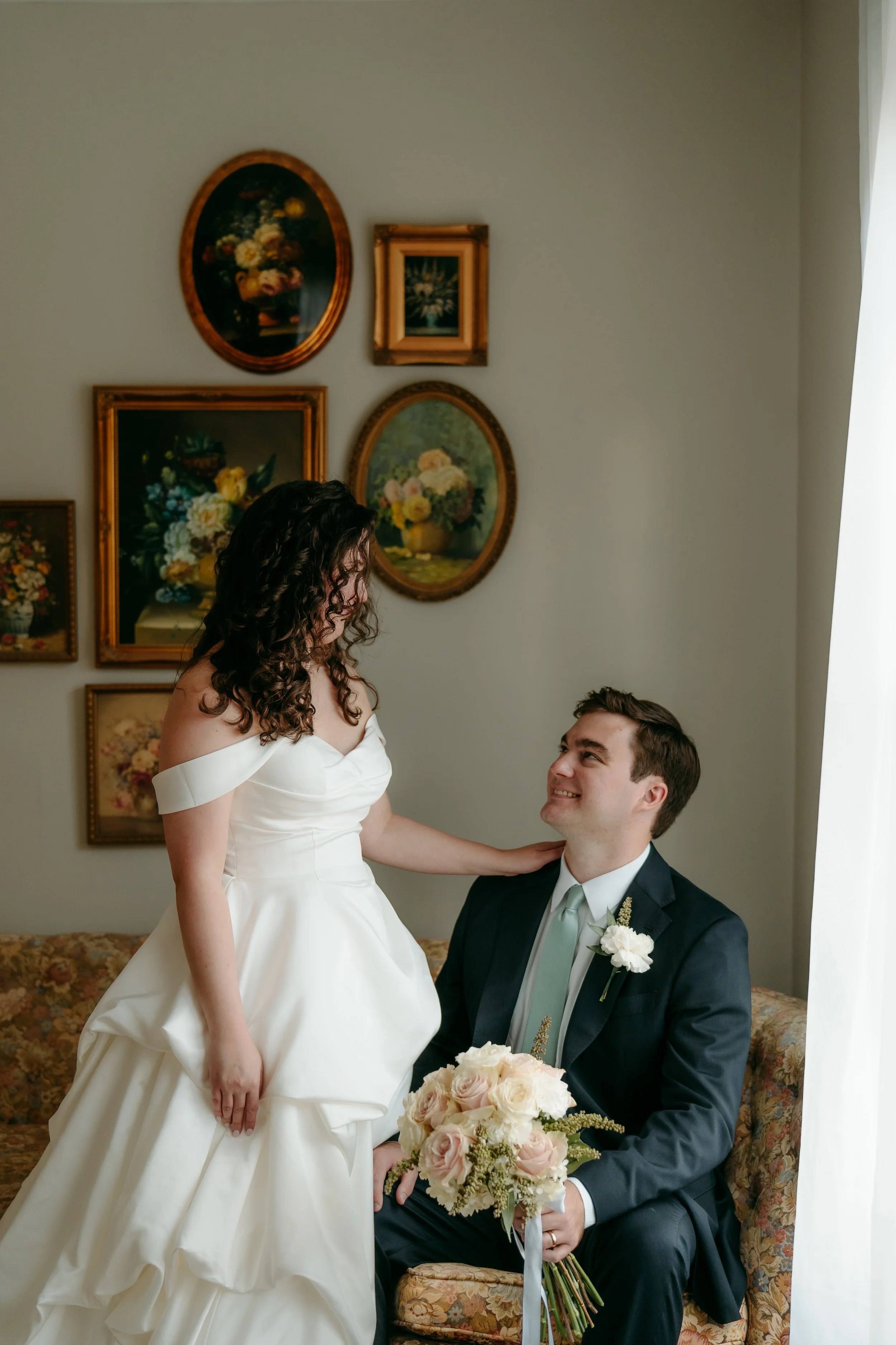 A couple sharing a kiss on their wedding day, with the groom gently holding the bride's face and neck.