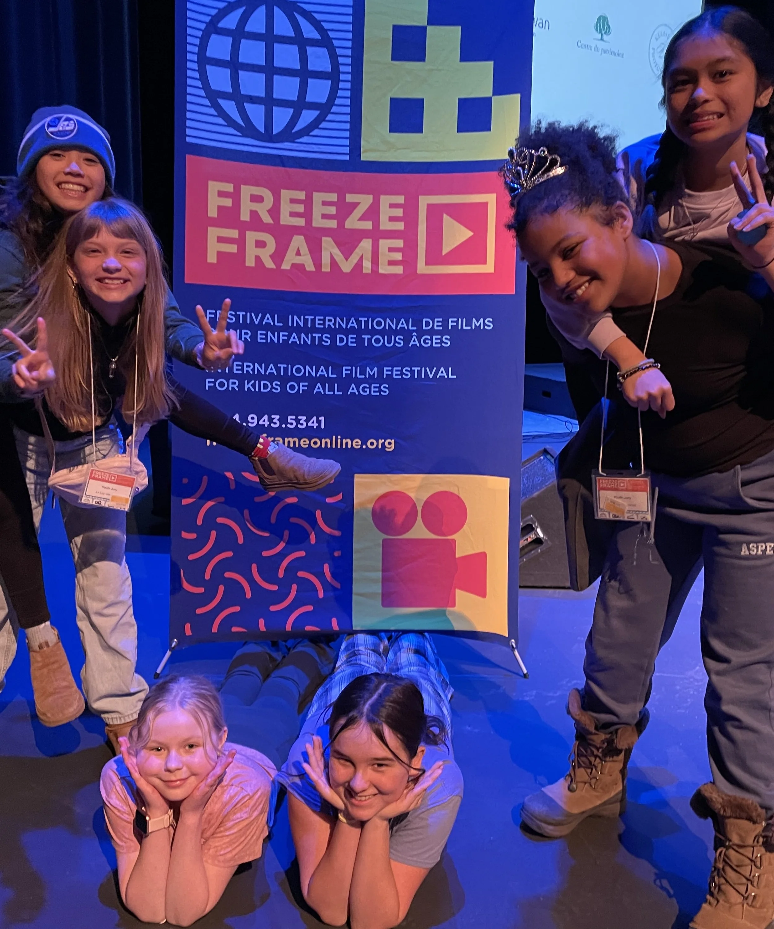 Six membres du jury des jeunes sur scène, devant une banderole « Freeze Frame »