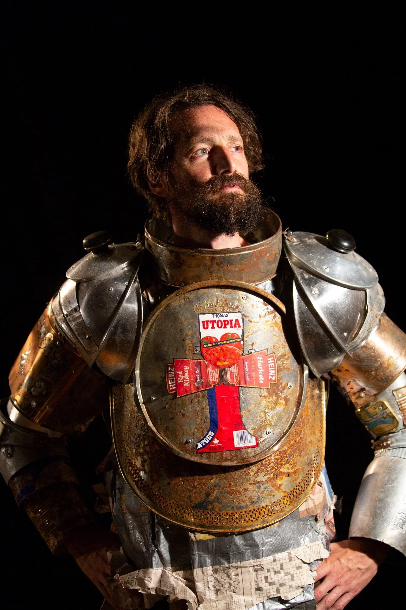 Curtis in a rusted handmade knight amour with a cross on the chest made from food labels