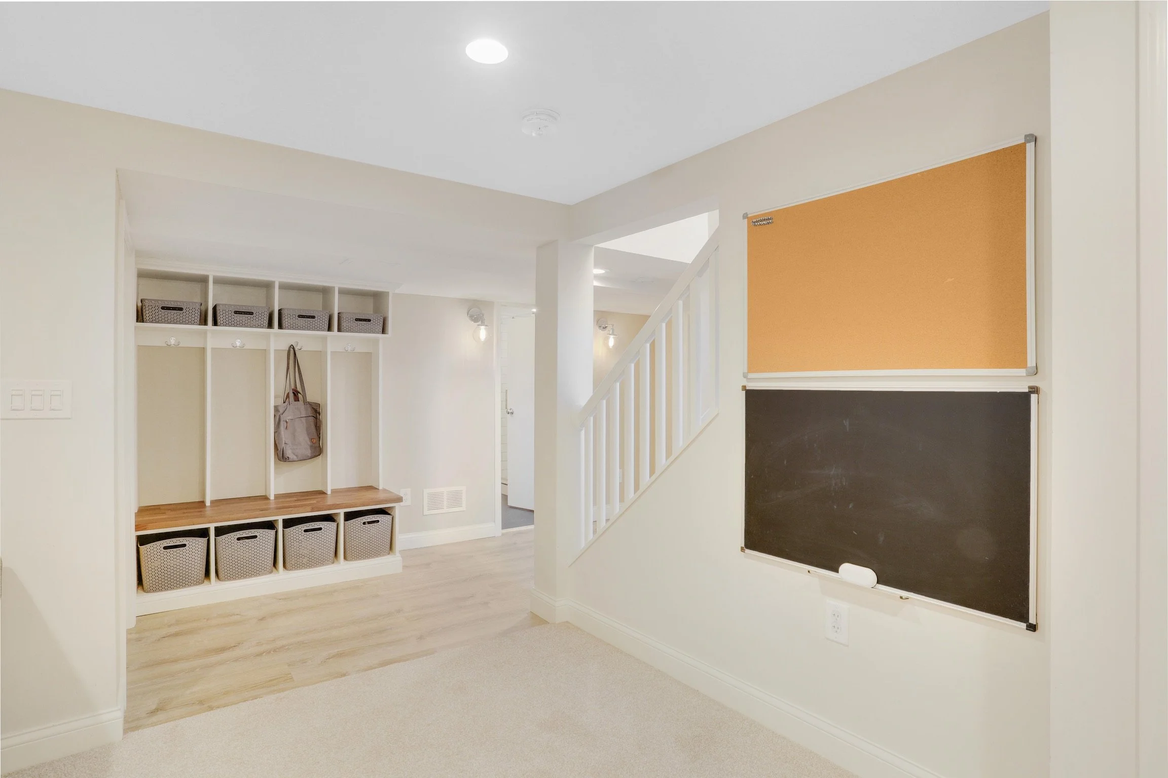 Interior view of a room with built-in storage, a staircase, and chalkboards on the wall.