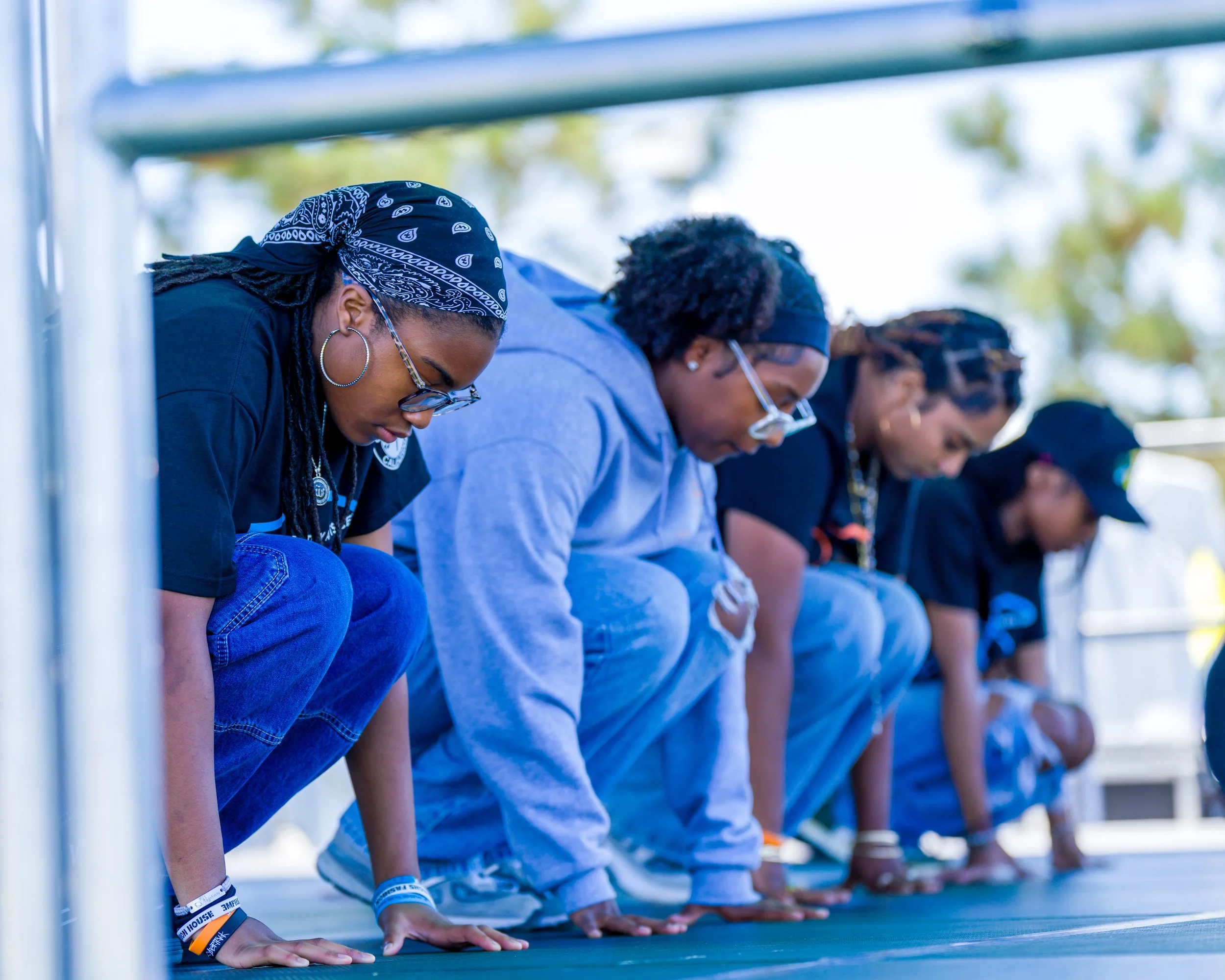 Group of young people doing push-ups outdoors on a sunny day