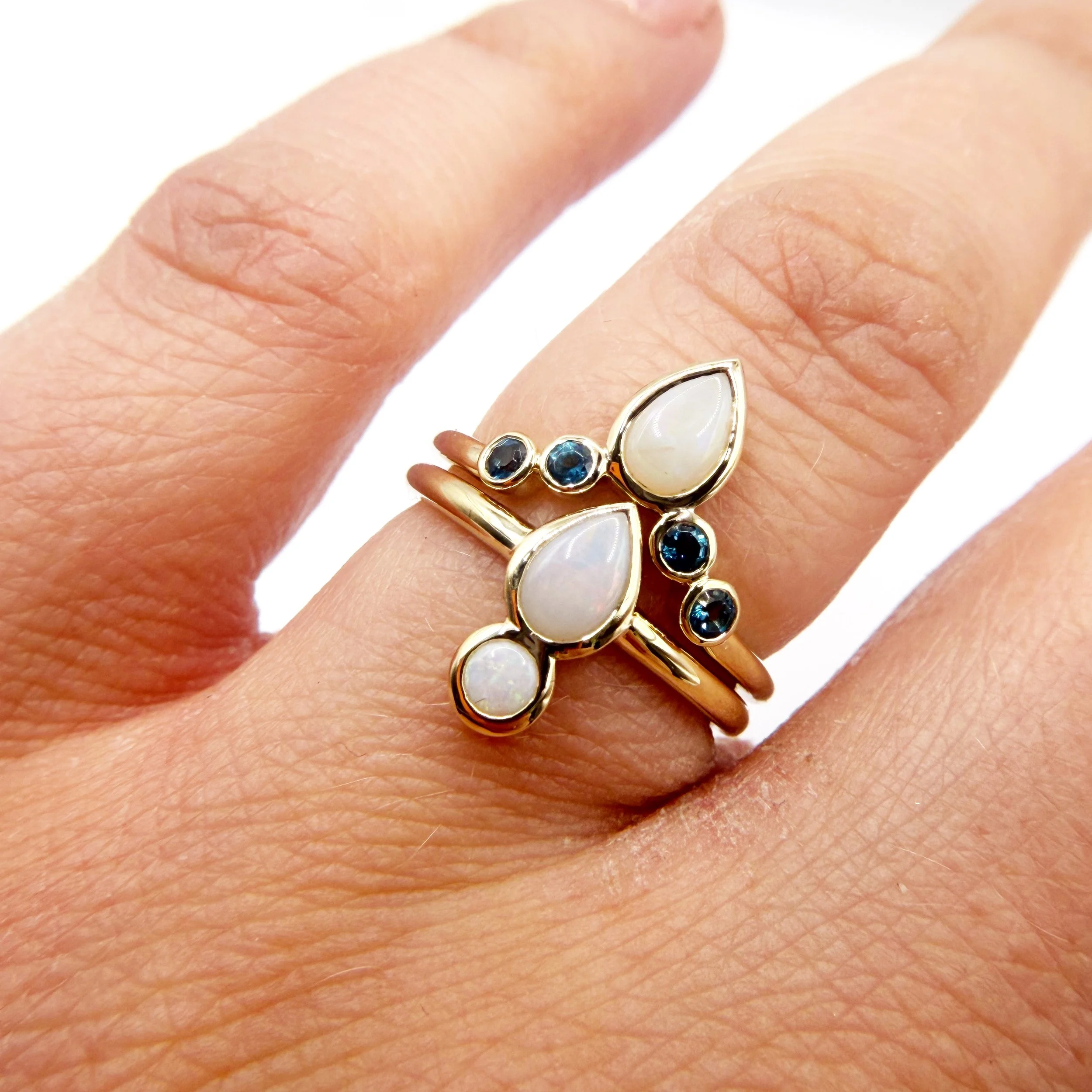 Opal and Sapphire gold ring on a finger
