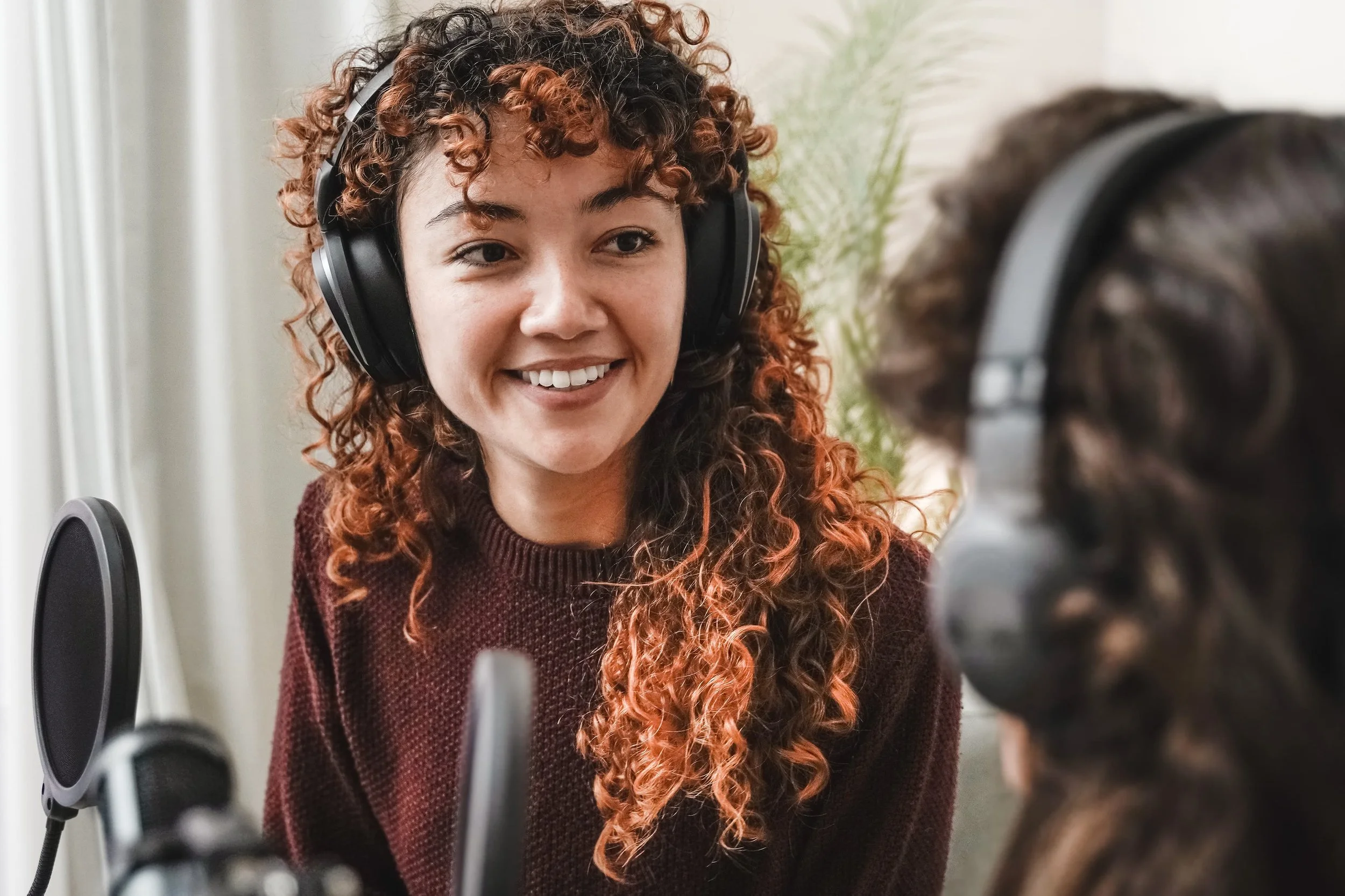 Young woman smiling while recording a podcast